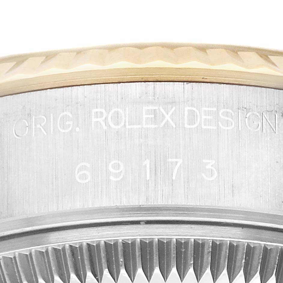 This image shows a close-up of the side case and bezel of a Rolex Datejust 69173 Women's Steel and Gold (two tone) Champagne Dial 69173 Women's Steel and Gold (two tone) Champagne Dial watch, featuring the model number and "Orig. Rolex Design" engraving.