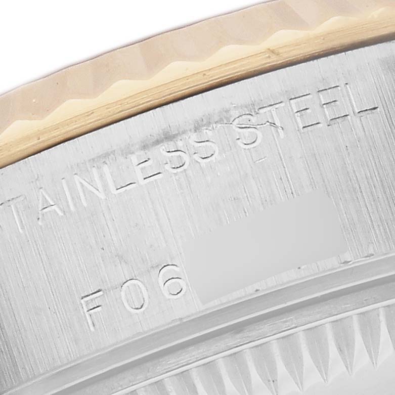 The image shows a close-up of the Rolex Datejust 79173 Women
s Steel and Gold (two tone) Mother of Pearl Dial 79173 Women
s Steel and Gold (two tone) Mother of Pearl Dial watch
s bezel and case edge, focusing on the "STAINLESS STEEL" engraving.