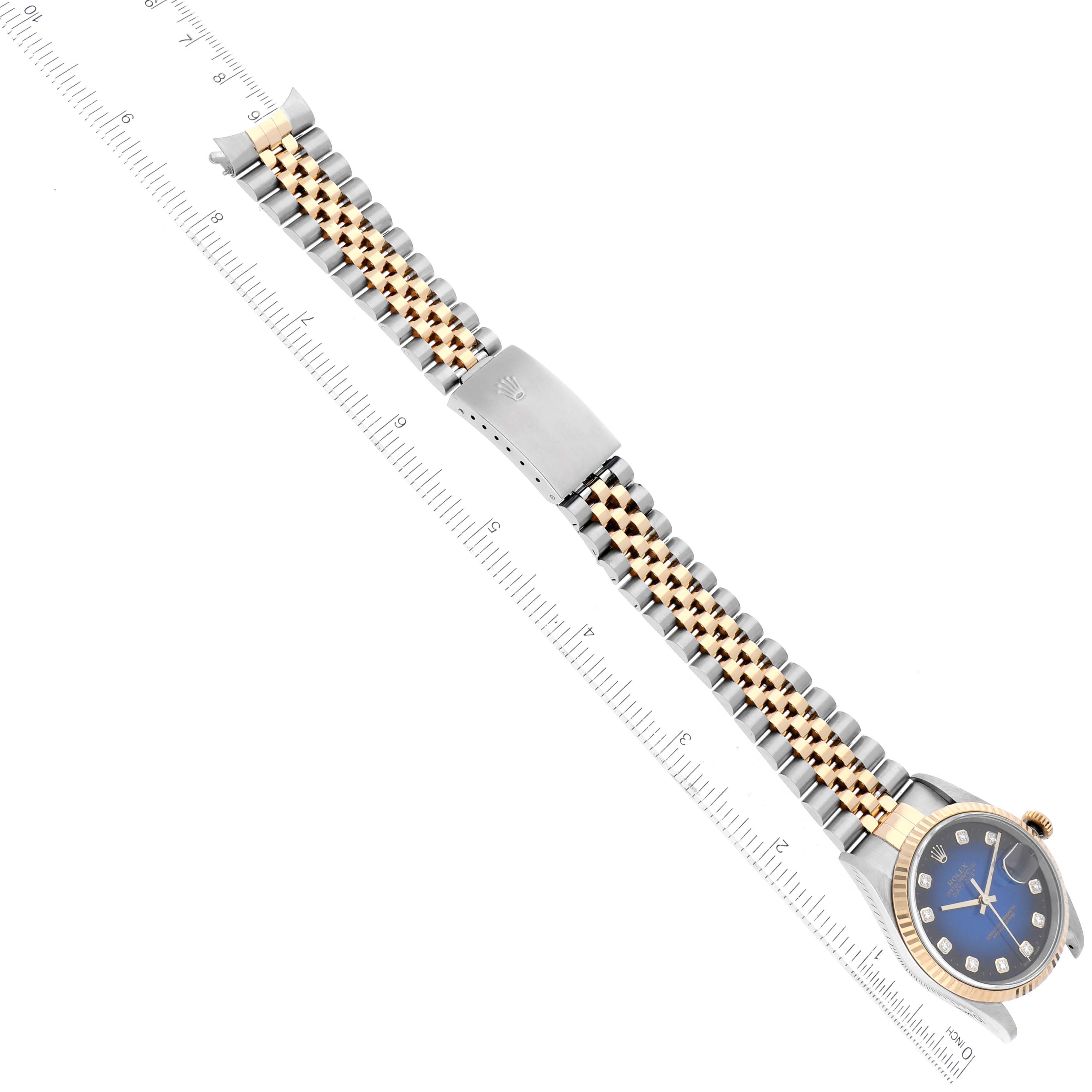 The image shows a Rolex Datejust 16233 Men's Steel and Gold (two tone) Blue Dial 16233 Men's Steel and Gold (two tone) Blue Dial watch from a top-down angle, displaying the face, bezel, and two-tone bracelet alongside a ruler.
