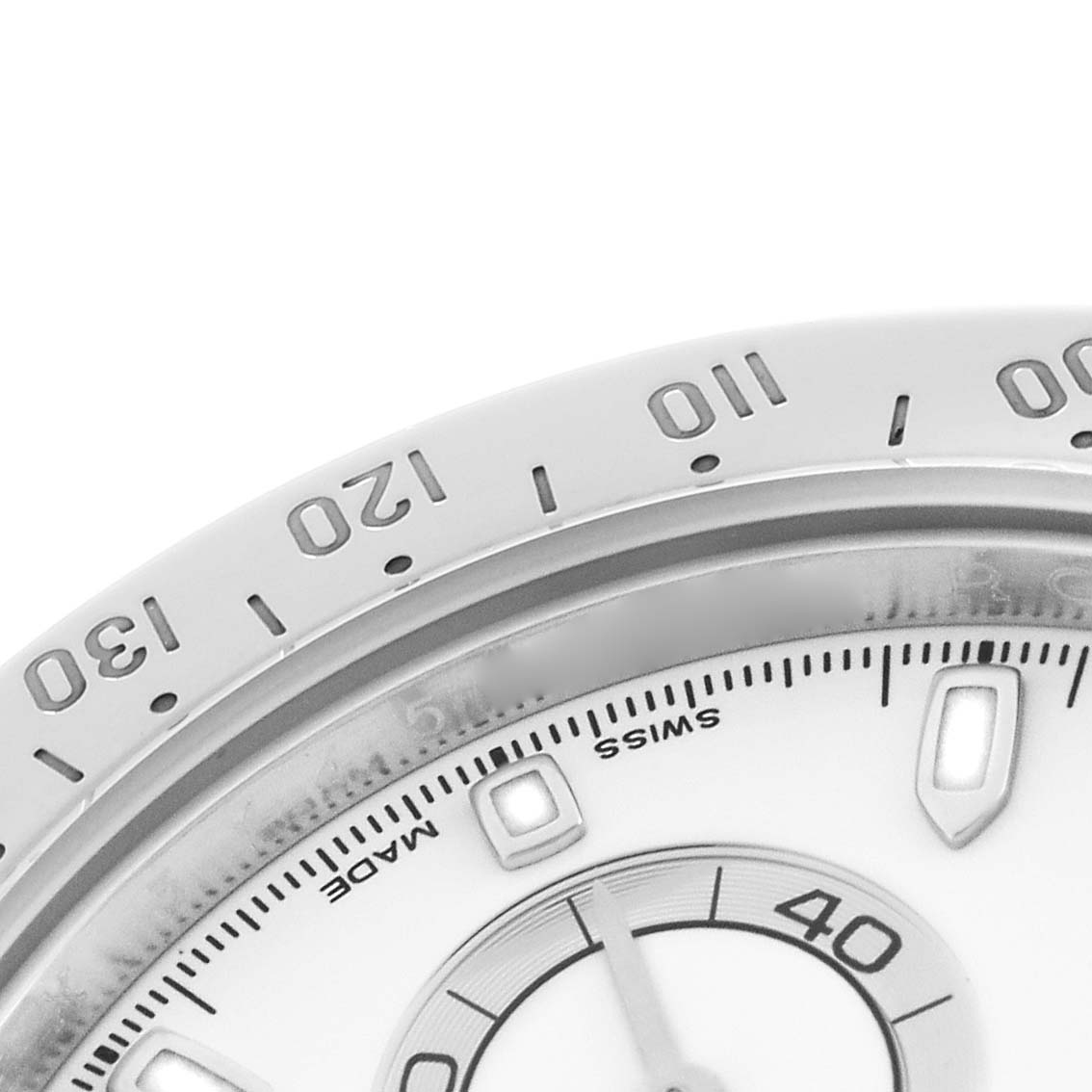 The image shows a close-up of the bezel, dial, and part of a sub-dial of the Rolex Daytona 116520 Men's Stainless Steel White Dial watch.
