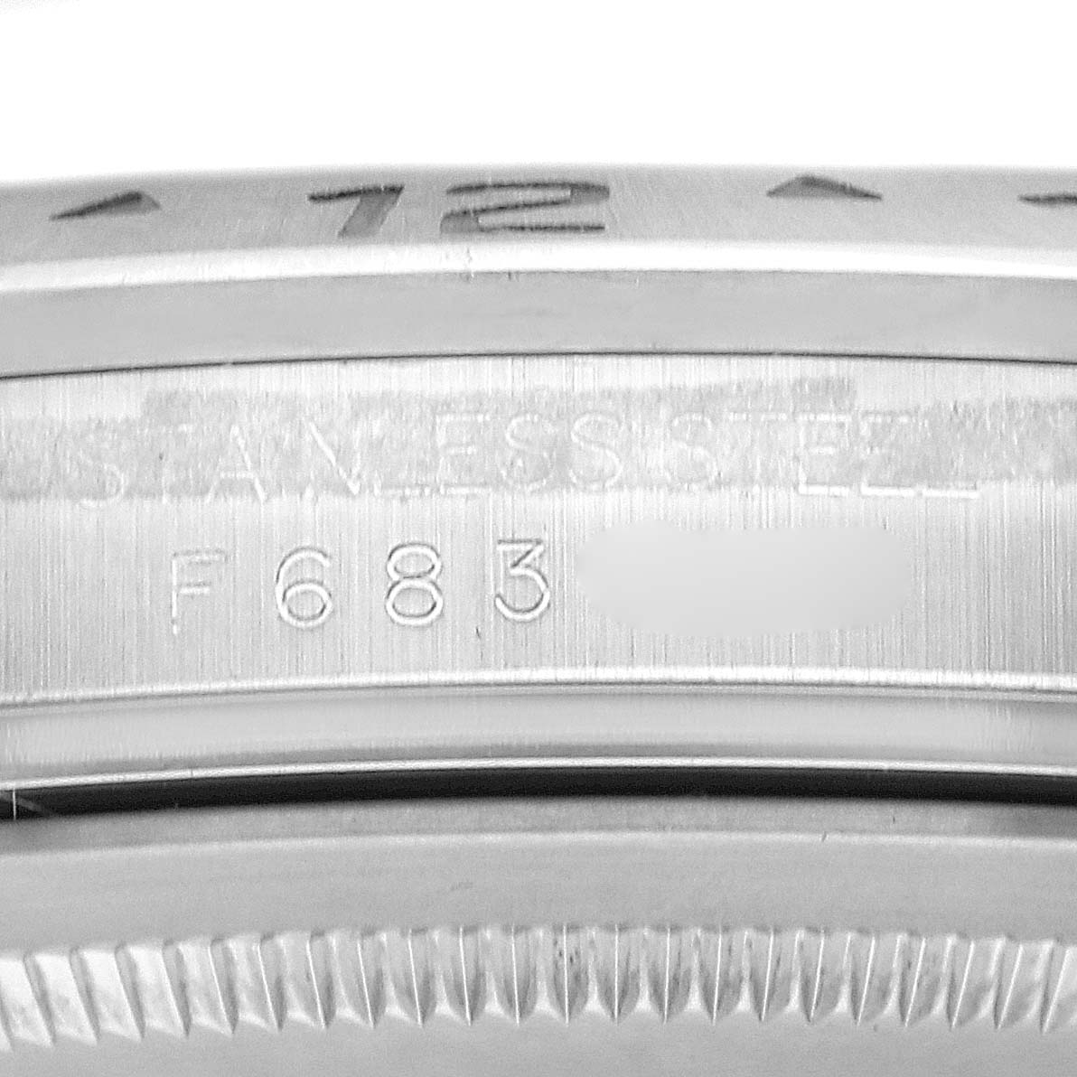 The image shows a close-up of a Rolex Explorer 16570 Men
s Stainless Steel Black Dial 16570 Men
s Stainless Steel Black Dial watch case, focusing on the edge and serial number engraving.