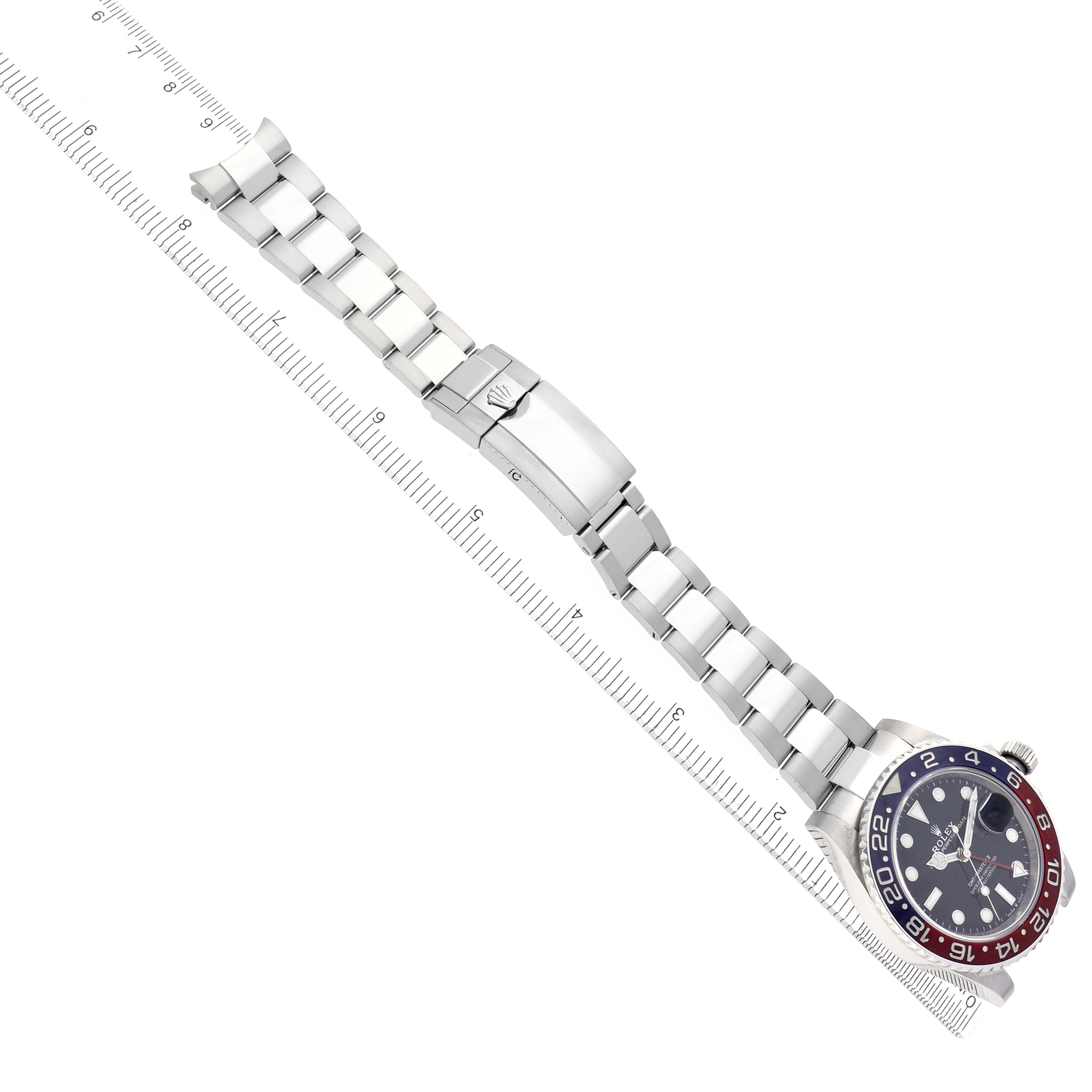 The image shows a Rolex GMT-Master 126710BLRO Men
s Stainless Steel Black Dial 126710BLRO Men
s Stainless Steel Black Dial watch laid flat with its band and clasp visible, alongside a measuring ruler.