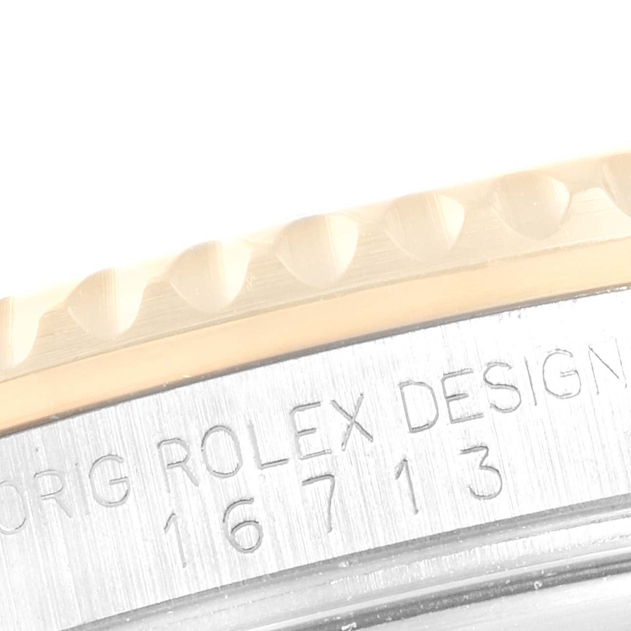 This image shows a close-up of the engraved bezel and case side of a Rolex GMT-Master 16713 Men
s Steel and Gold (two tone) Black Dial 16713 Men
s Steel and Gold (two tone) Black Dial model.