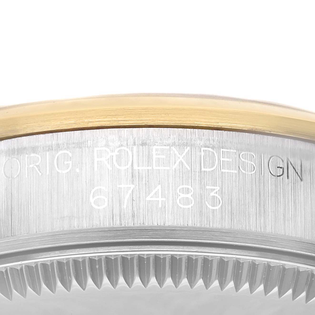 The image shows a close-up of the edge and side of a Rolex Mid-Size 67483 Women's Steel and Gold (two tone) Silver Dial 67483 Women's Steel and Gold (two tone) Silver Dial model, featuring the engraved serial number and "ROLEX DESIGN".