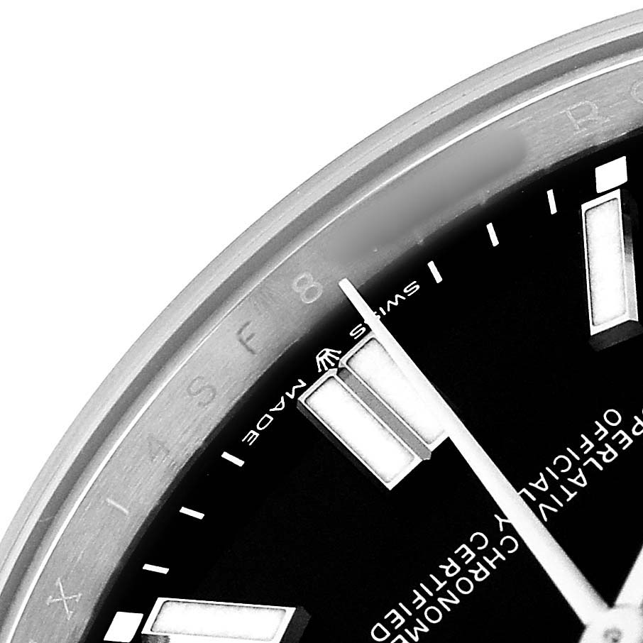 The image shows a close-up of the dial and bezel of a Rolex Oyster Perpetual M124300-0002 Mens Stainless Steel Black Dial watch at an angle focusing on the markers.