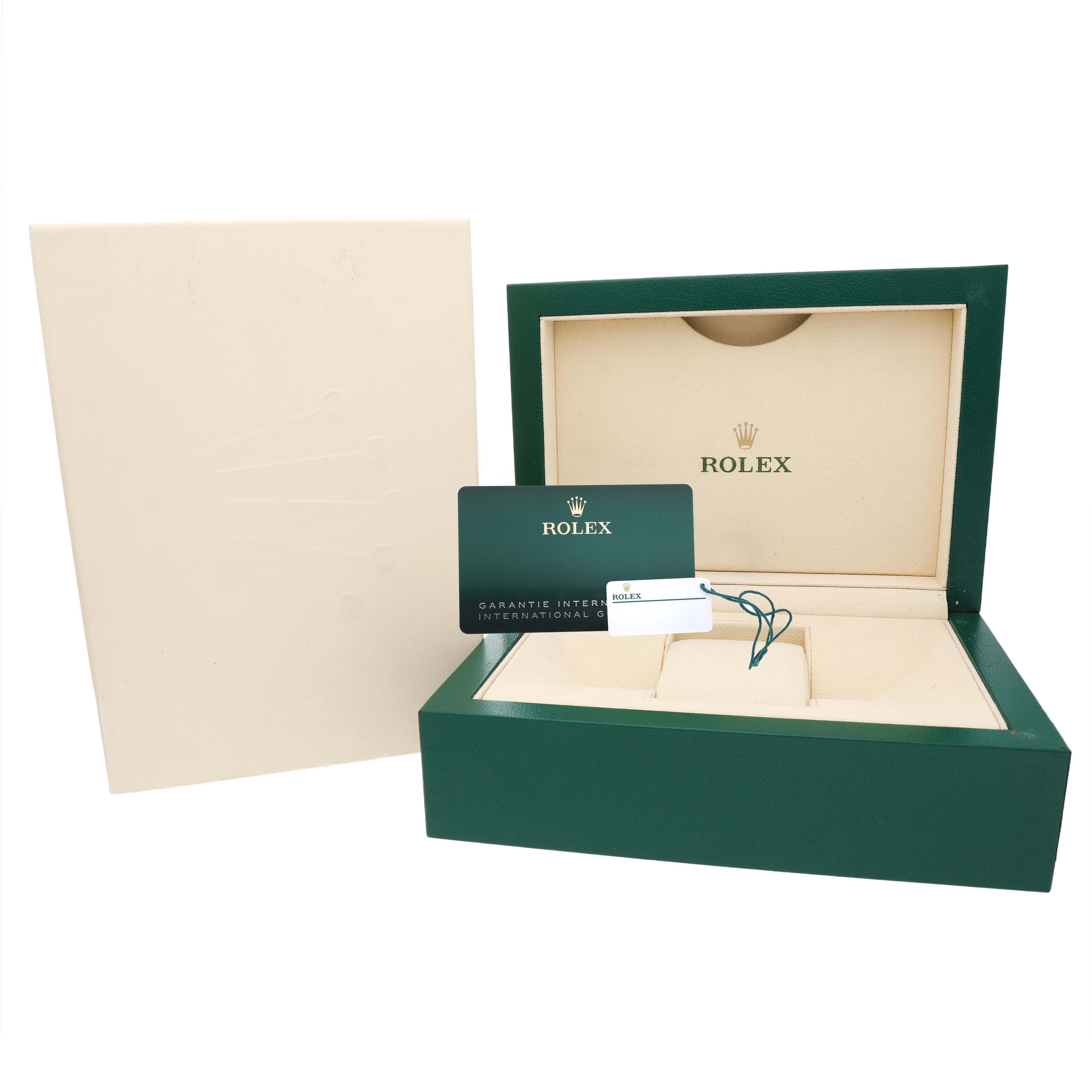 The image shows the open box of a Rolex Oyster Perpetual 124300 Men's Stainless Steel Blue Dial watch with the warranty card and tags.