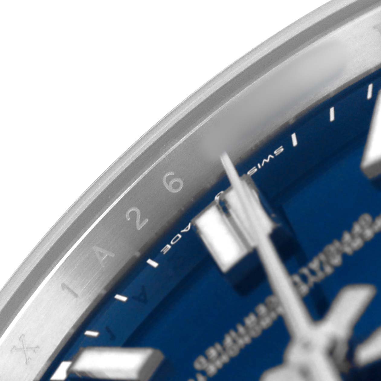 The image shows a close-up of the Rolex Oyster Perpetual 124300 Men's Stainless Steel Blue Dial watch face, highlighting the bezel and part of the blue dial with hour markers.