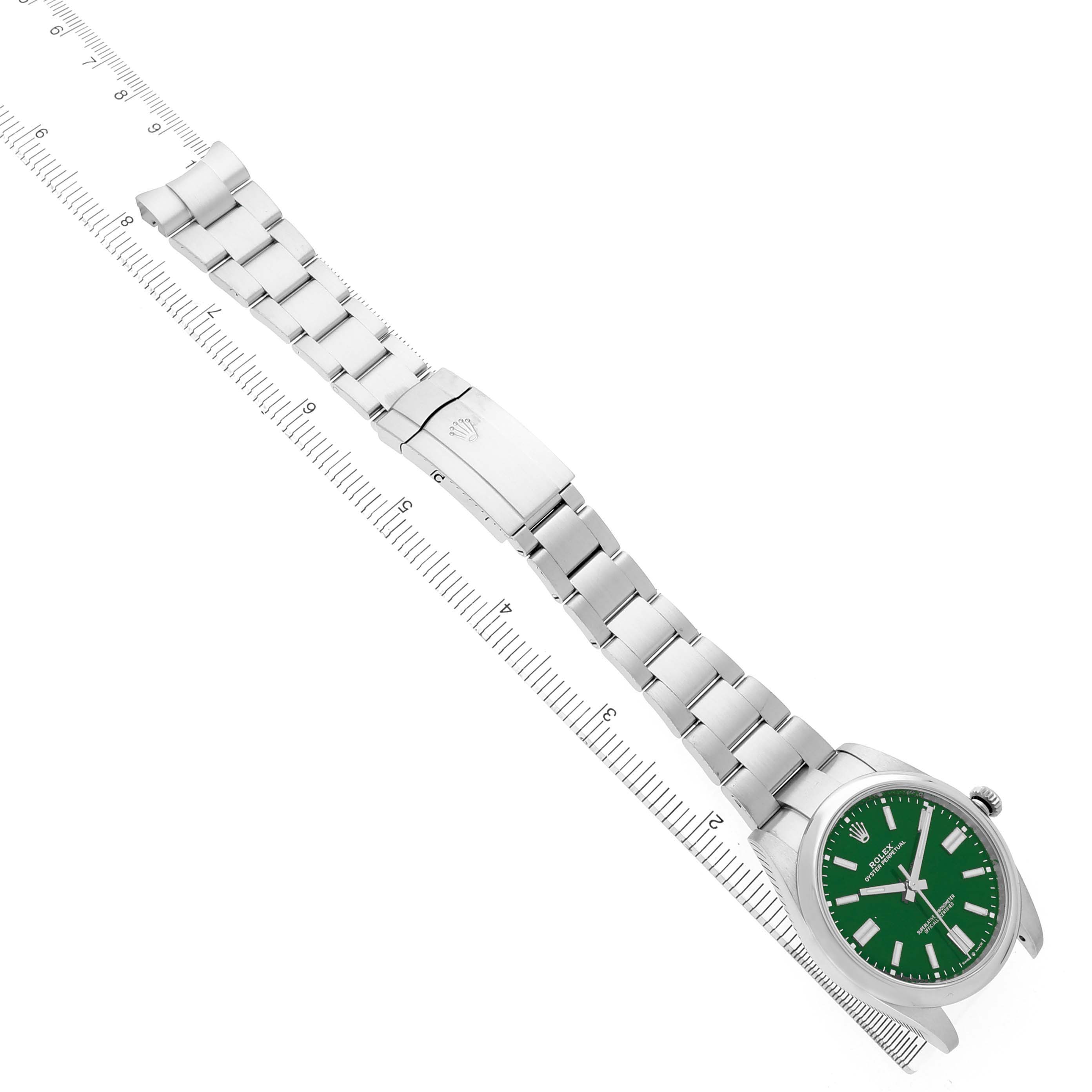 The Rolex Oyster Perpetual M124300-0005 Men's Stainless Steel Green Dial watch is shown at an overhead angle, highlighting its green dial, bracelet, and clasp.