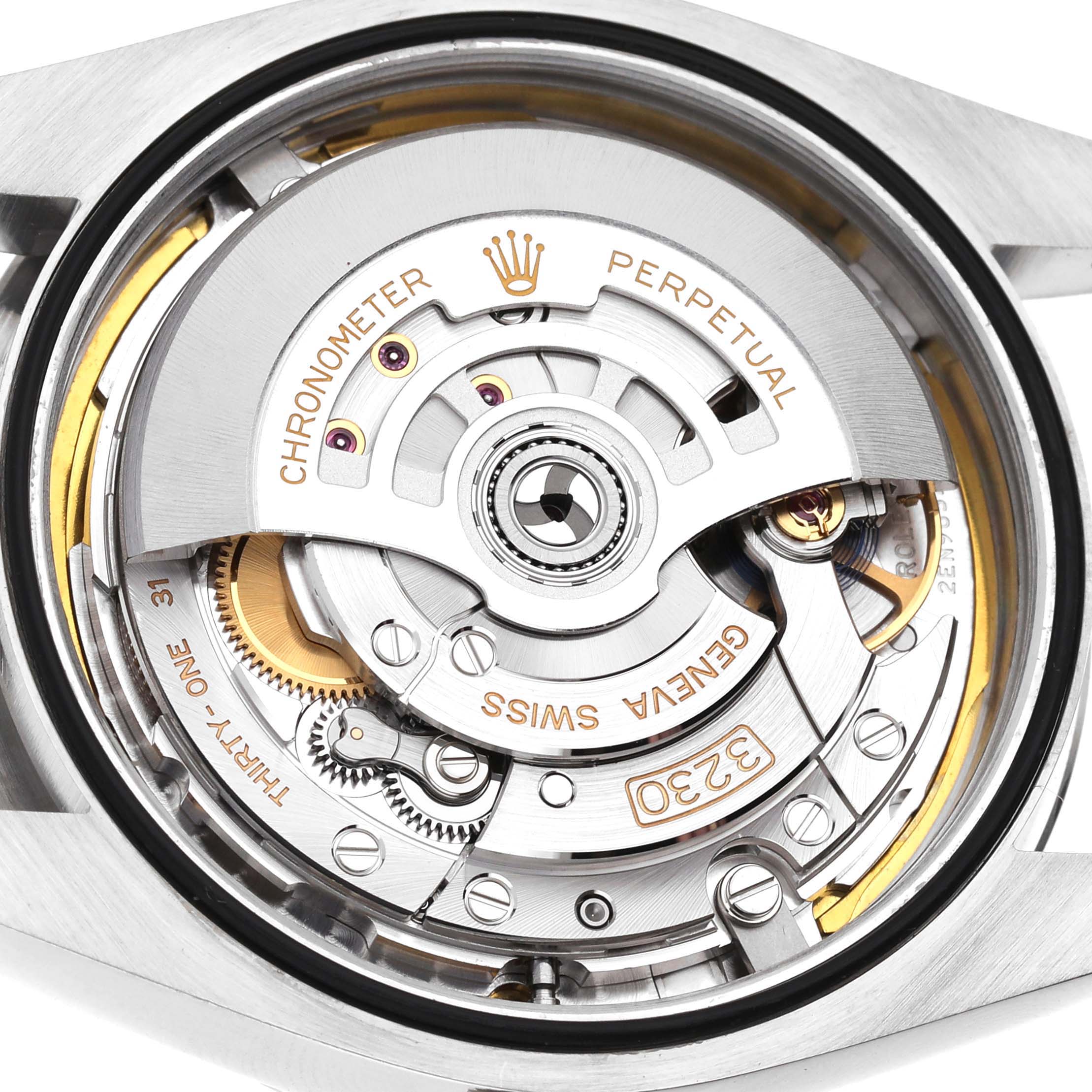 The image shows a close-up view of the movement mechanism of a Rolex Oyster Perpetual M124300-0005 Men's Stainless Steel Green Dial watch.