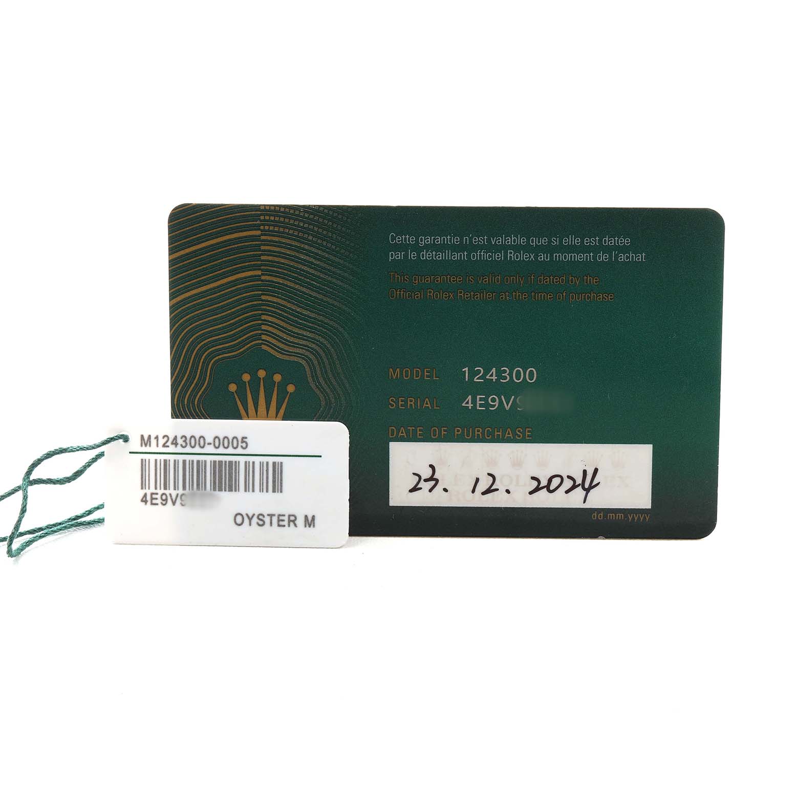 The image shows a Rolex Oyster Perpetual M124300-0005 Men's Stainless Steel Green Dial warranty card and a tag with model and serial numbers.