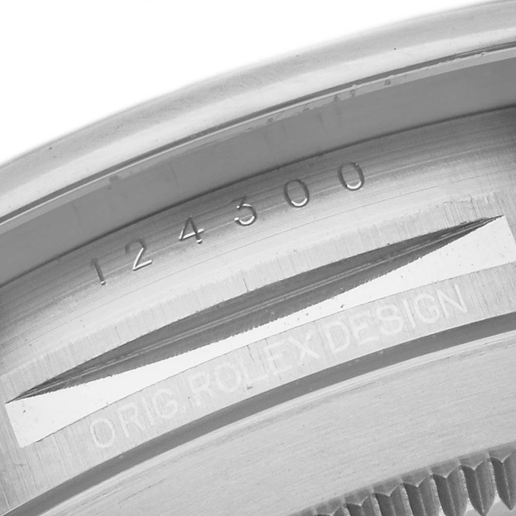 This image shows the inner rim of the case back of a Rolex Oyster Perpetual 124300 Men
s Stainless Steel Red Dial 124300 Men
s Stainless Steel Red Dial watch, displaying the model number and "ORIG. ROLEX DESIGN" engraving.