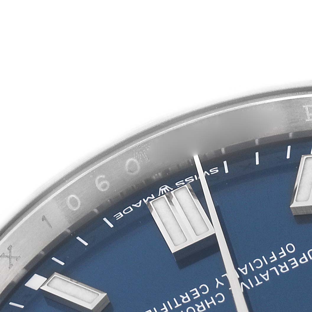 The image shows the top part of the dial and bezel of a Rolex Oyster Perpetual 126000 Men
s Stainless Steel Blue Dial 126000 Men
s Stainless Steel Blue Dial watch.