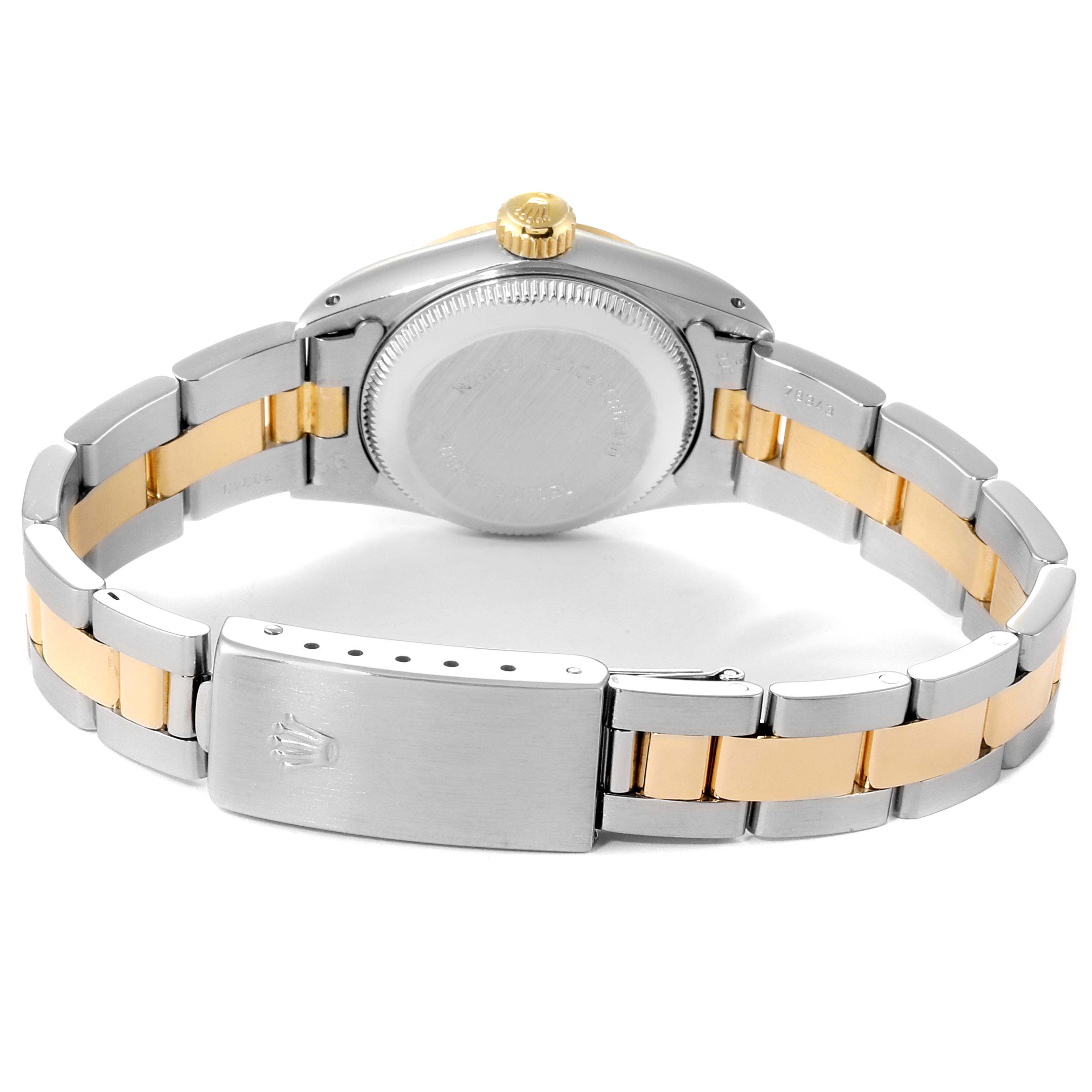 This image shows the back view of a Rolex Oyster Perpetual 67243 Women
s Steel and Gold (two tone) Champagne Dial 67243 Women
s Steel and Gold (two tone) Champagne Dial watch, highlighting its case, gold crown, and two-tone bracelet.