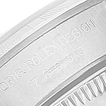 The image shows a close-up of the engraved edge of a Rolex Oyster Perpetual 76030 Women
s Stainless Steel Pink Dial 76030 Women
s Stainless Steel Pink Dial watch, specifically the text "ORIG. ROLEX DESIGN" and the number "76630".