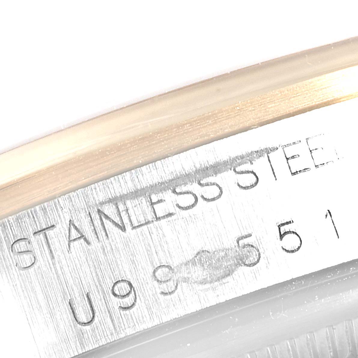 This image shows a close-up of the case back serial engraving of the Rolex Oyster Perpetual 14203 Men's Steel and Gold (two tone) Blue Dial 14203 Men's Steel and Gold (two tone) Blue Dial watch, highlighting the "Stainless Steel" text and serial number.