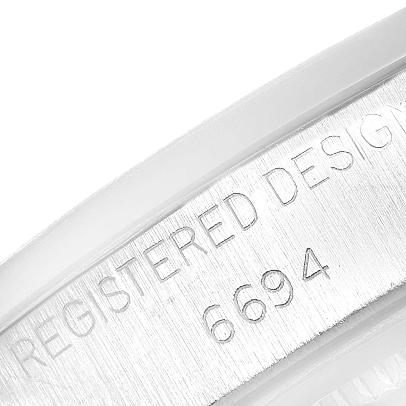 This image shows a close-up of the engraved case serial number and "Registered Design" text on the Rolex Vintage Collection 6694 Men
s Stainless Steel Silver Dial 6694 Men
s Stainless Steel Silver Dial model 6694.