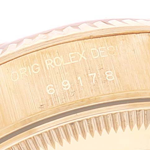 This close-up image of the Rolex President 69178 Women
s Yellow Gold Champagne Dial 69178 Women
s Yellow Gold Champagne Dial model watch shows the engraved serial number on its bezel.