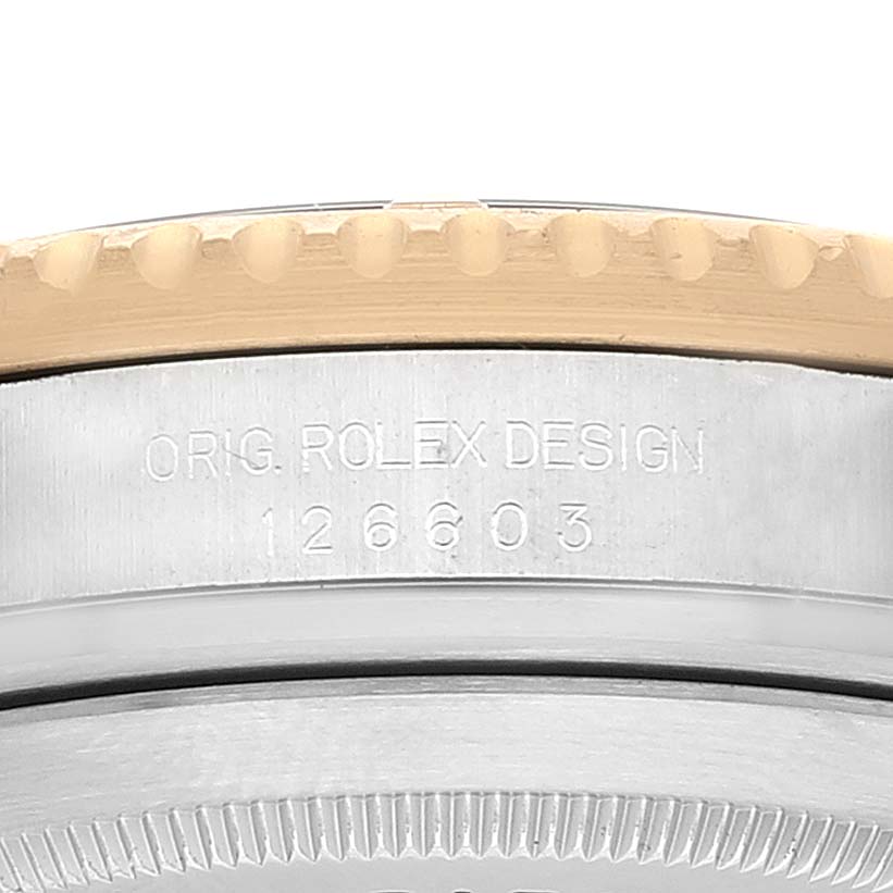 The image shows a close-up of the side of a Rolex Sea-Dweller 126603 Men
s Steel and Gold (two tone) Black Dial 126603 Men
s Steel and Gold (two tone) Black Dial model, highlighting the model number 126603 and the engraved "ORIG. ROLEX DESIGN."