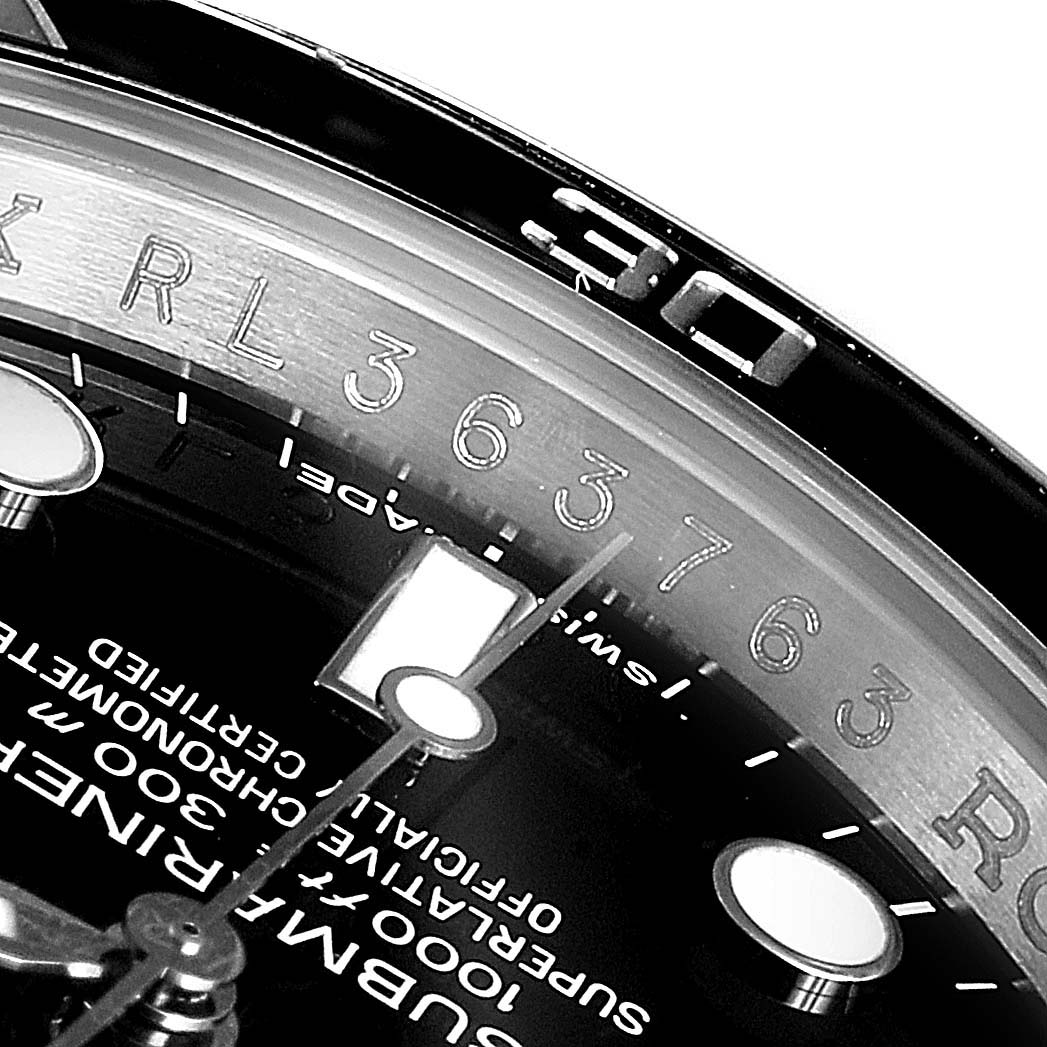 This close-up image of a Rolex Submariner 114060 Men
s Stainless Steel Black Dial 114060 Men
s Stainless Steel Black Dial watch shows the dial, minute indices, hands, and part of the rotating bezel.