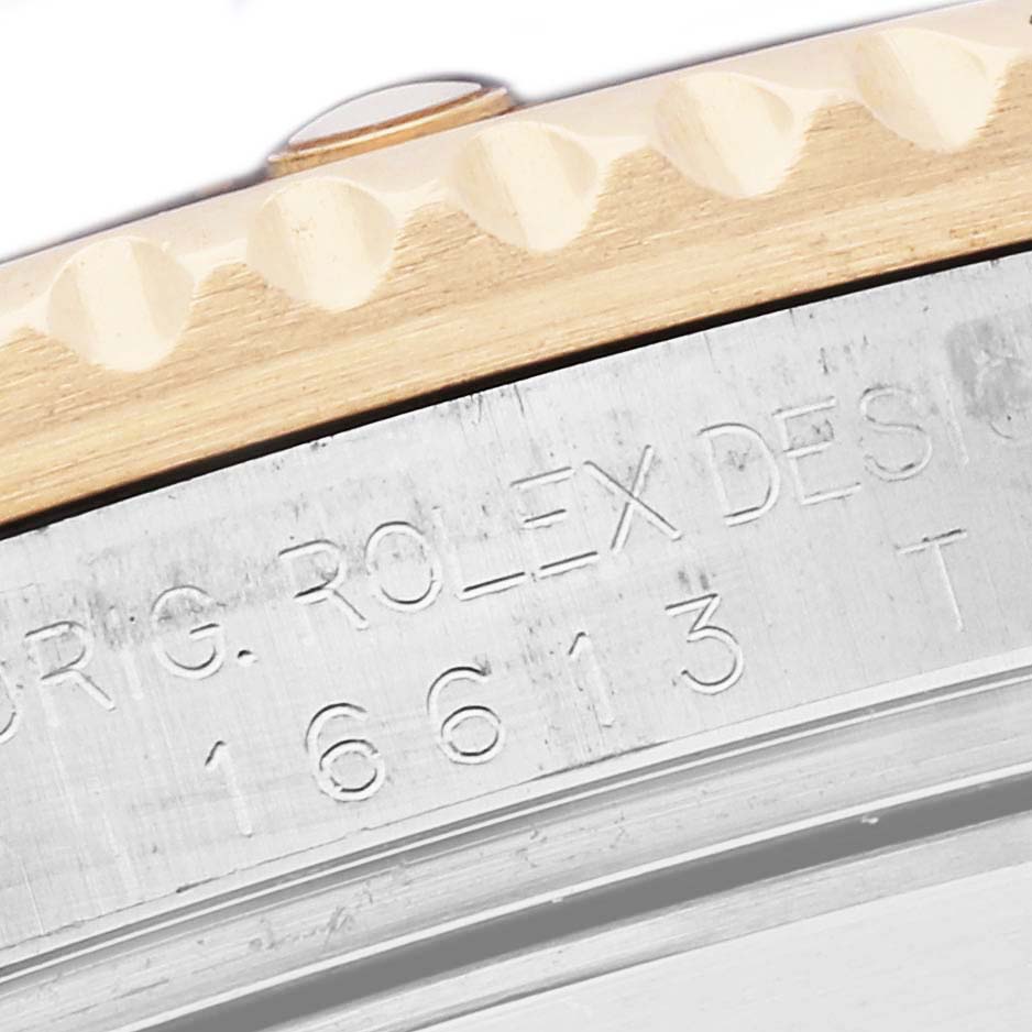 The image shows a close-up of the Rolex Submariner 16613 Men
s Steel and Gold (two tone) Black Dial 16613 Men
s Steel and Gold (two tone) Black Dial model
s engraved bezel edge and case side, highlighting model details.