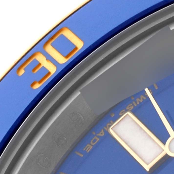 This close-up shot of the Rolex Submariner 116613 Men's Steel and Gold (two tone) Blue Dial 116613 Men's Steel and Gold (two tone) Blue Dial model focuses on the bezel with the number 30 and a portion of the dial with hour indices.