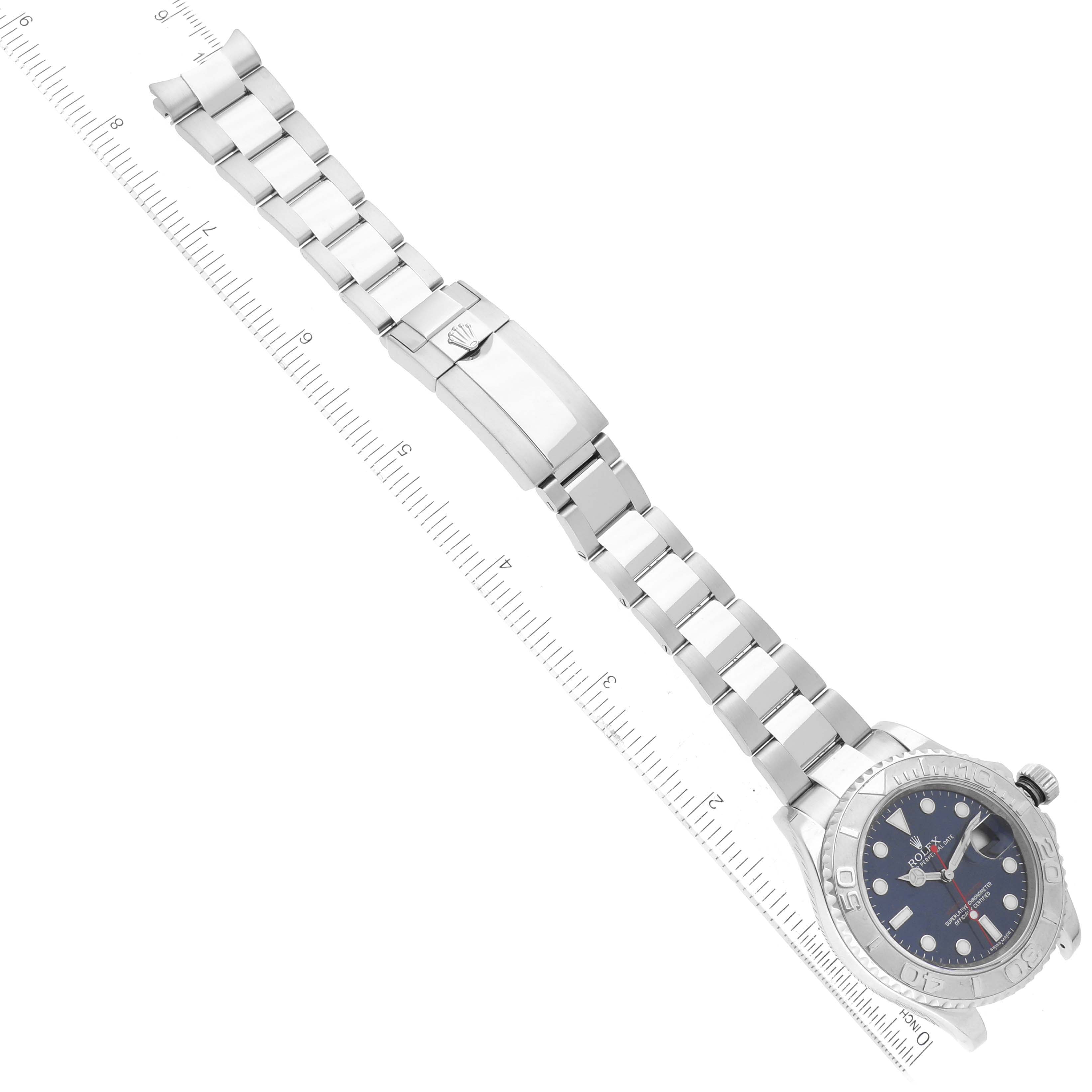 The Rolex Yacht-Master 116622 Men's Stainless Steel Blue Dial 116622 Men's Stainless Steel Blue Dial watch is shown from a top-down angle with its full bracelet and clasp visible next to a ruler for scale.