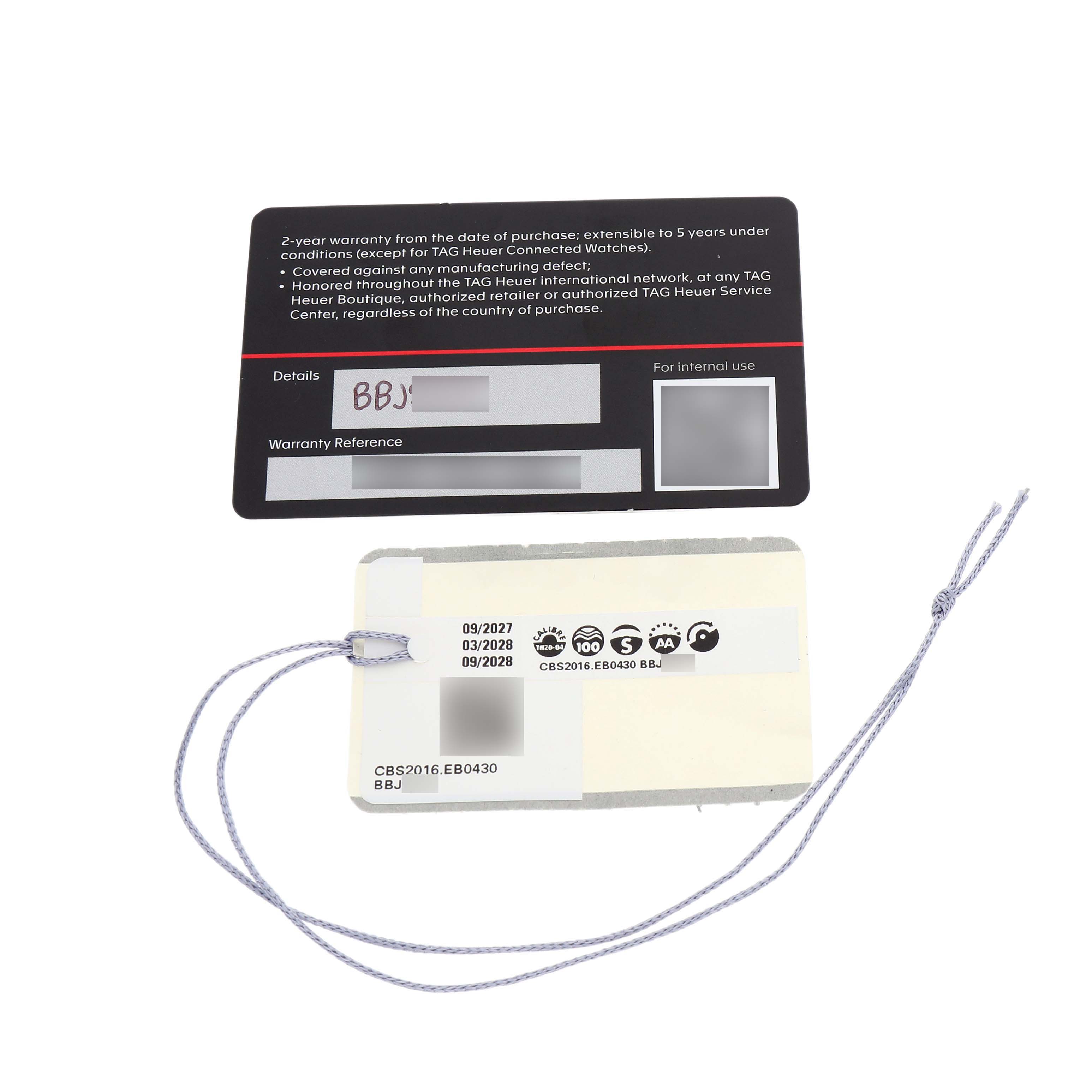 The image shows warranty cards and tags for the Carrera model by Tag Heuer, laid flat.
