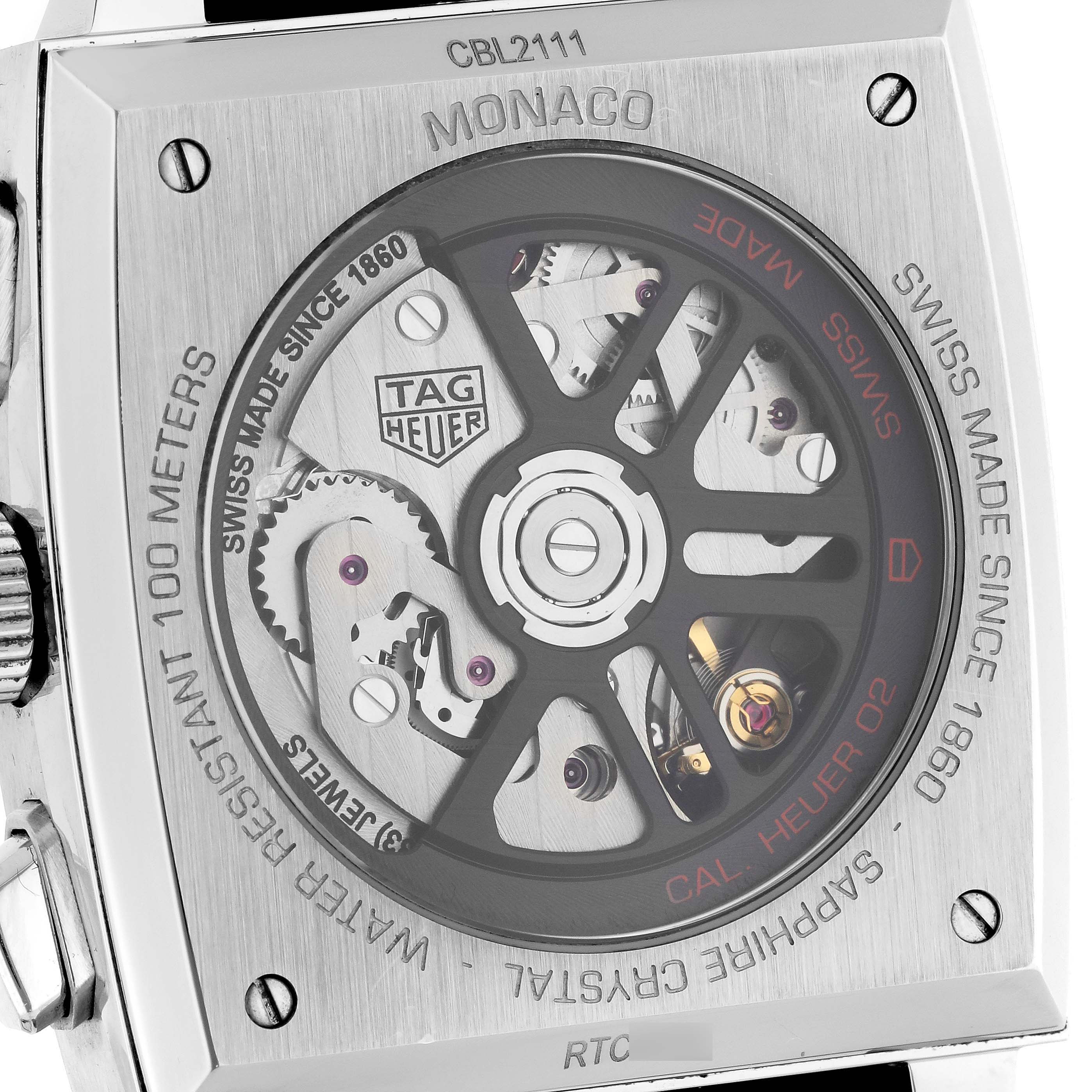 The image shows the back view of a Tag Heuer Monaco watch, highlighting its exposed mechanical movement and inscriptions.
