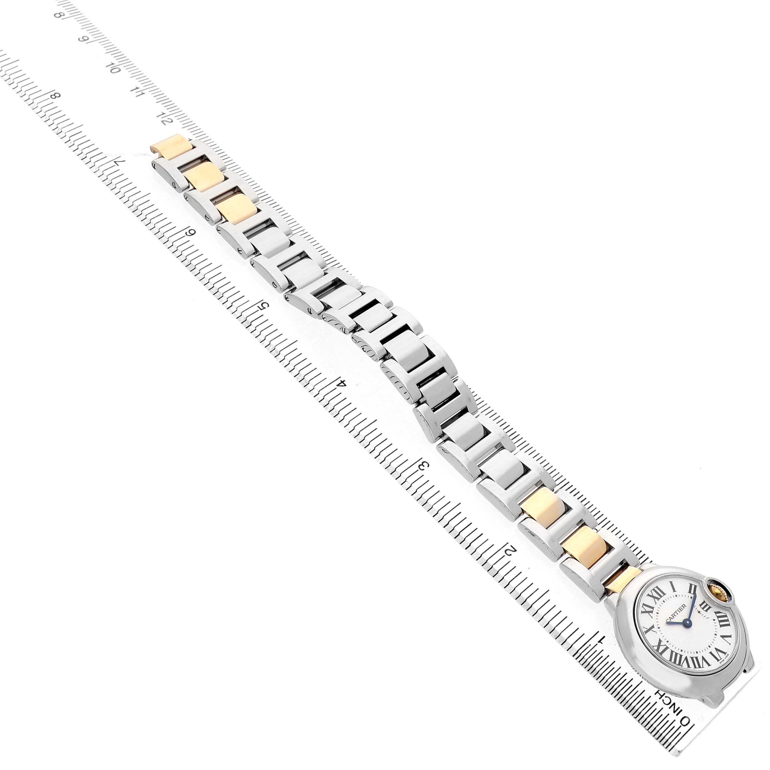 The Cartier Ballon Bleu W69007Z3 Women's Steel and Gold (two tone) Silver Dial watch is shown from an angled top view, displaying the bracelet and the face next to a ruler.