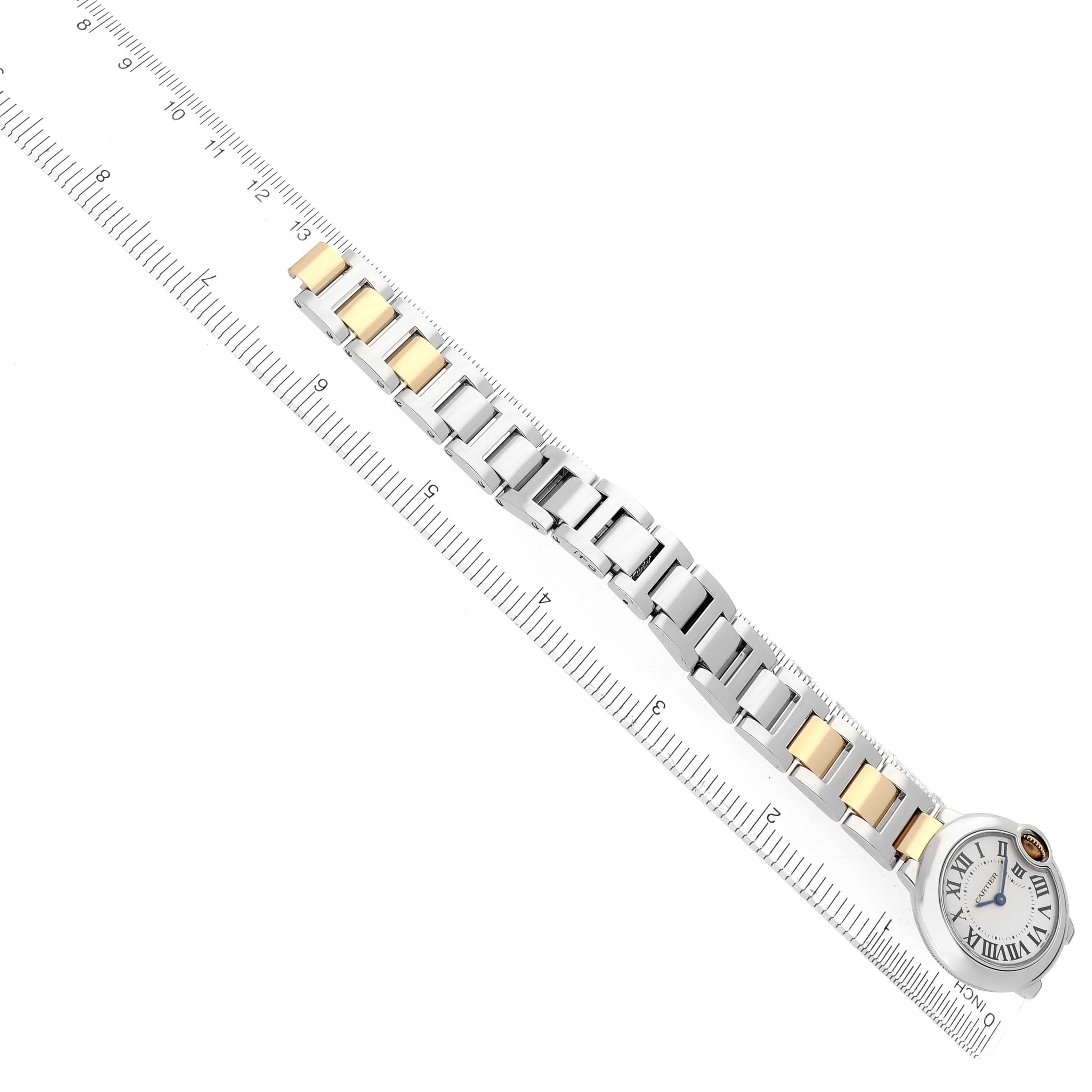 The Ballon Bleu by Cartier is shown from a top angle, highlighting its face, bracelet, and mixed metal links alongside a ruler.