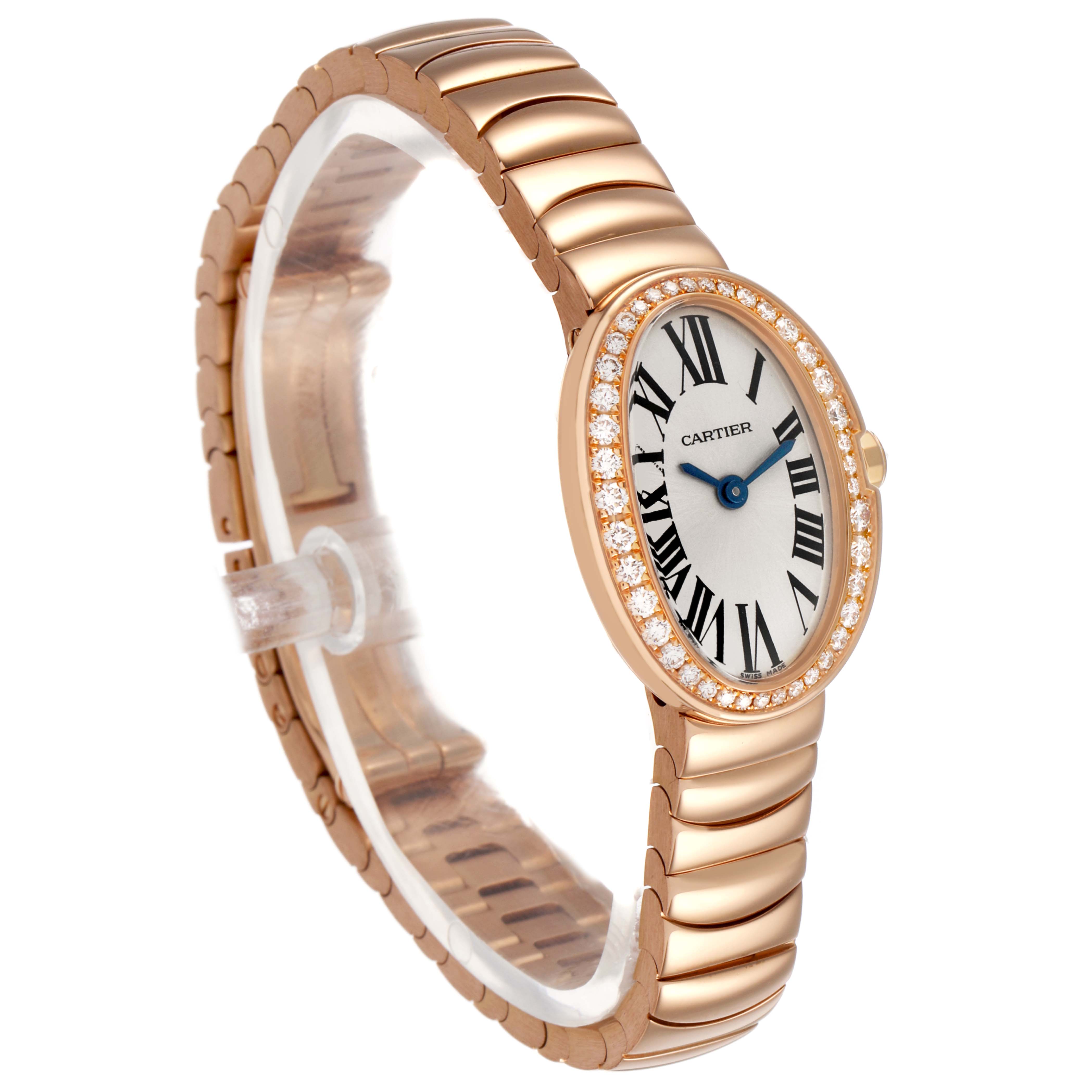 The Cartier Baignoire WB520026 Women's Rose Gold Silver Dial watch is shown at a three-quarter angle, displaying its oval face, diamond bezel, and gold bracelet.