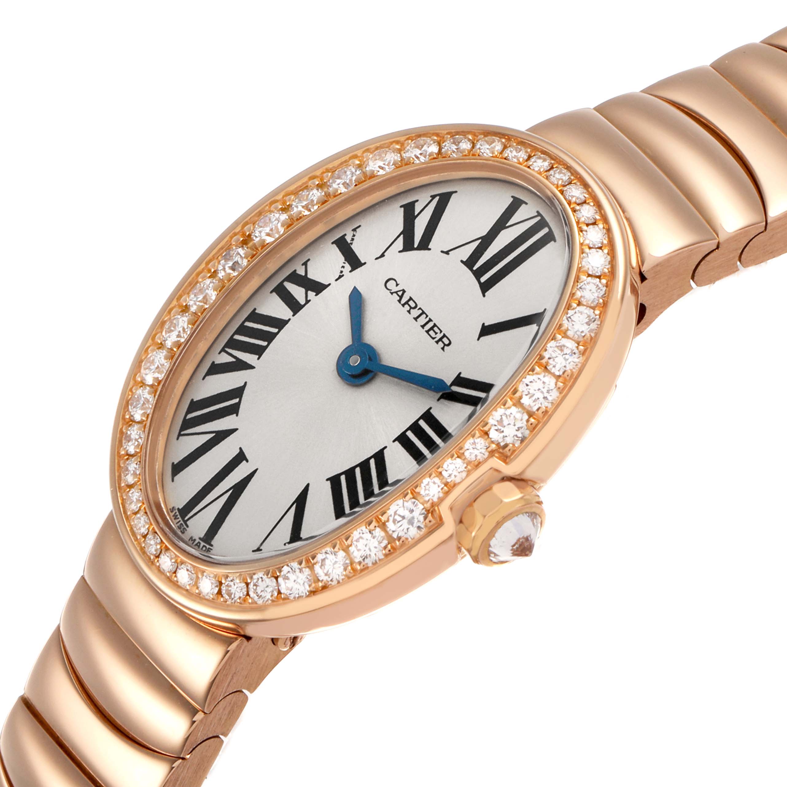 The Cartier Baignoire WB520026 Women's Rose Gold Silver Dial watch is shown at an angle displaying its oval face, diamond bezel, blue hands, and gold bracelet.