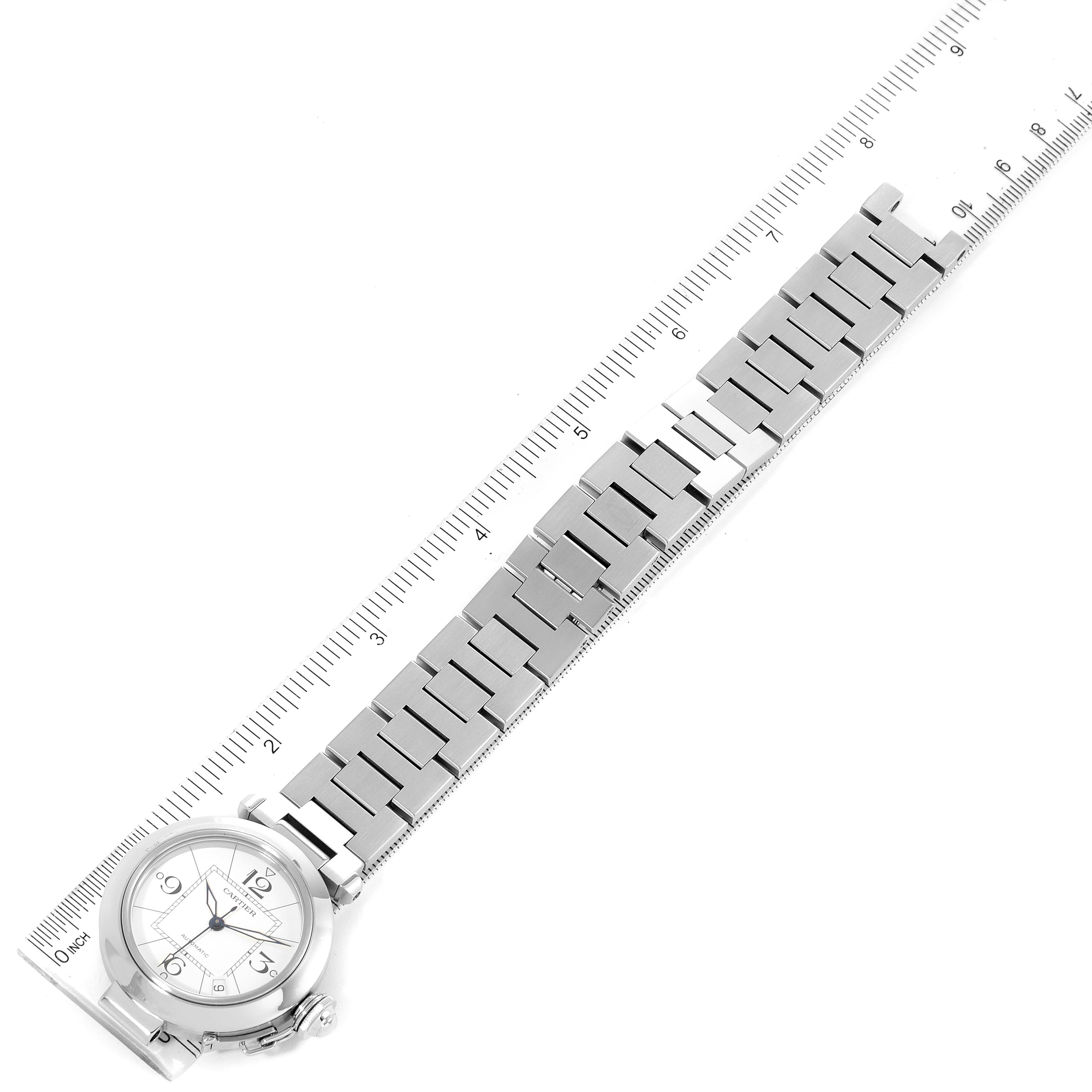 The image shows the Cartier Pasha W31074M7 Men
s Stainless Steel White Dial W31074M7 Men
s Stainless Steel White Dial watch laid flat with its face and metal bracelet aligned with a ruler for measurement.