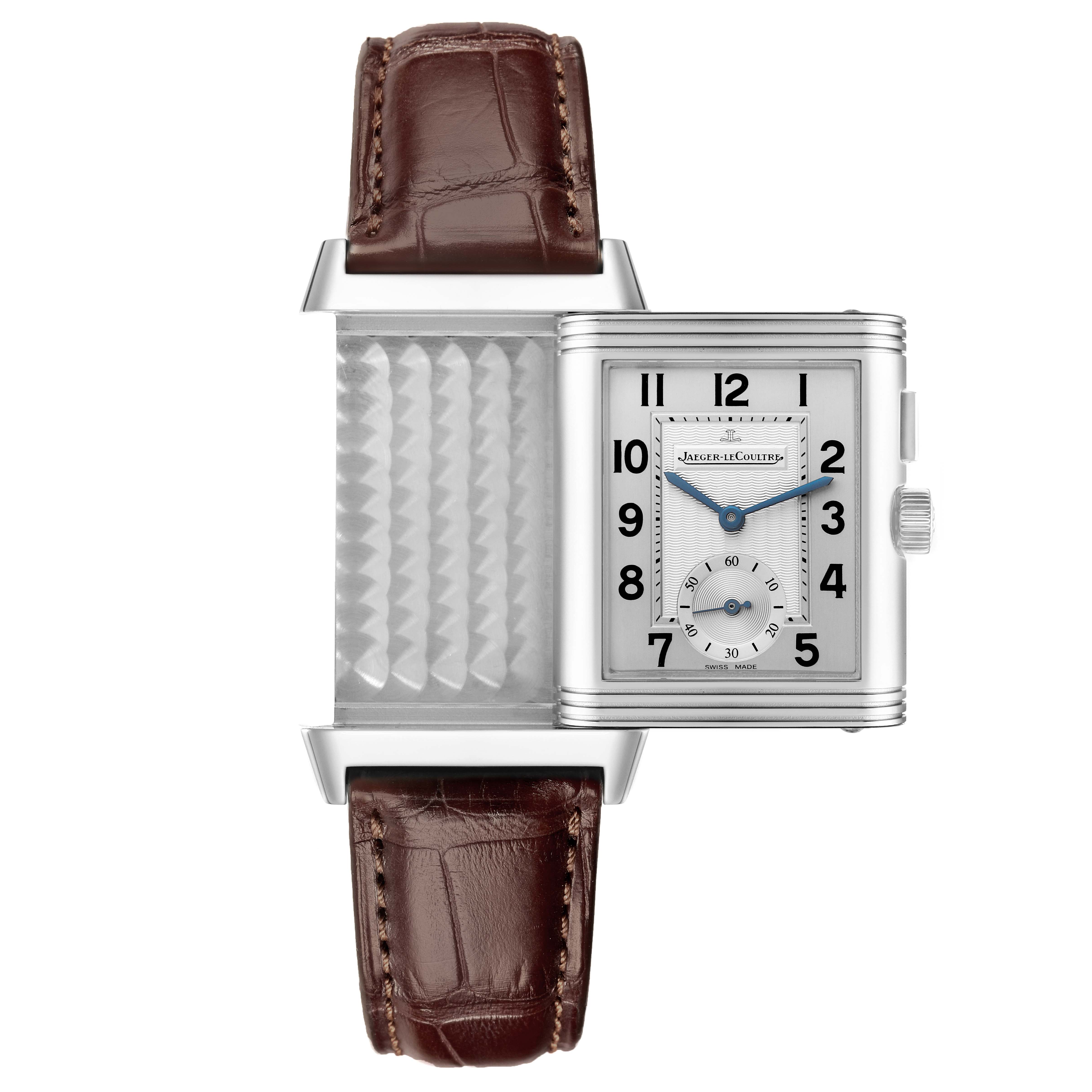 The Jaeger LeCoultre Reverso Q2718411 Men's Stainless Steel Silver Dial Q2718411 Men's Stainless Steel Silver Dial watch is shown partially flipped, revealing its mechanism and face with brown leather straps.