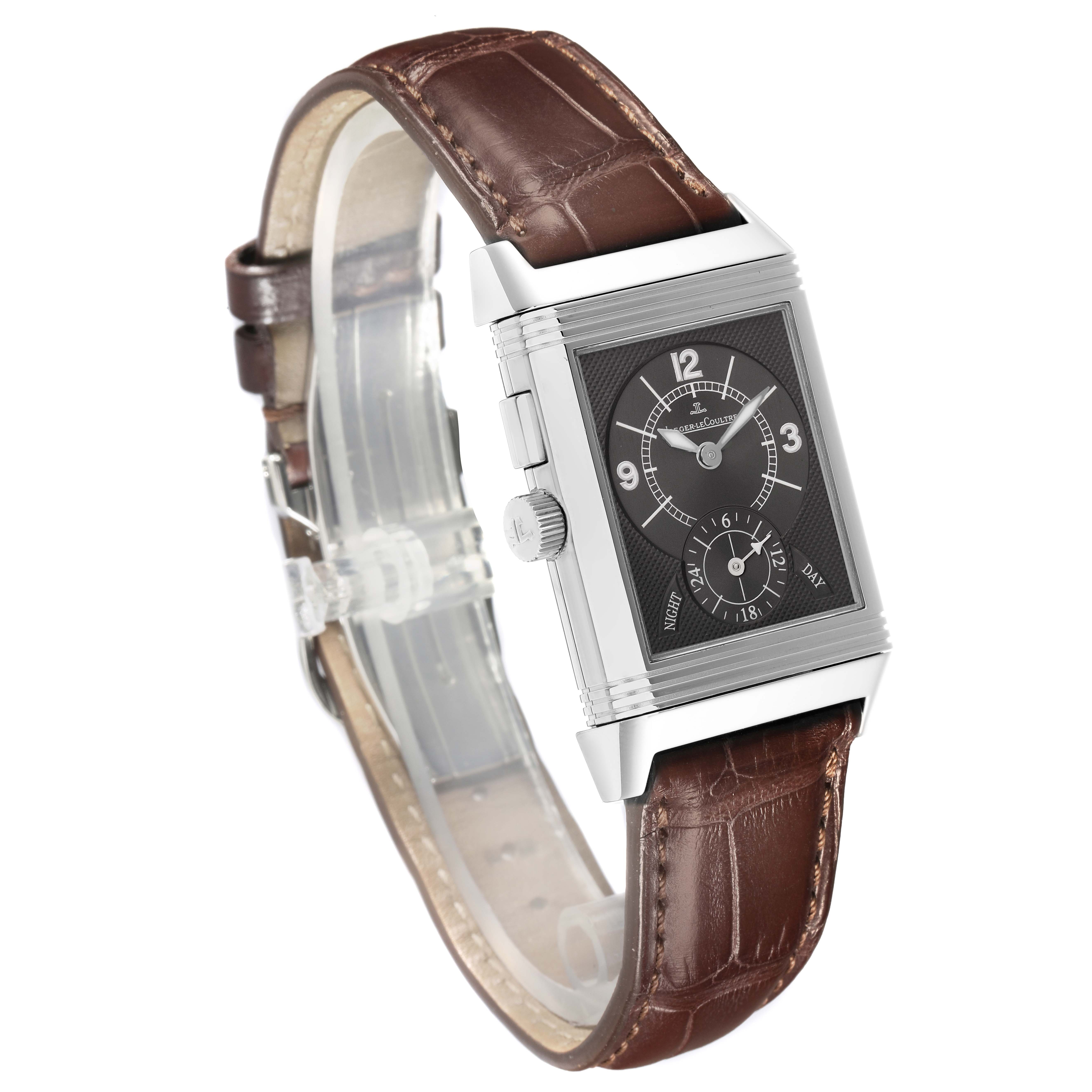 The Jaeger-LeCoultre Reverso watch is shown at a three-quarter angle, highlighting its rectangular dial and brown leather strap.