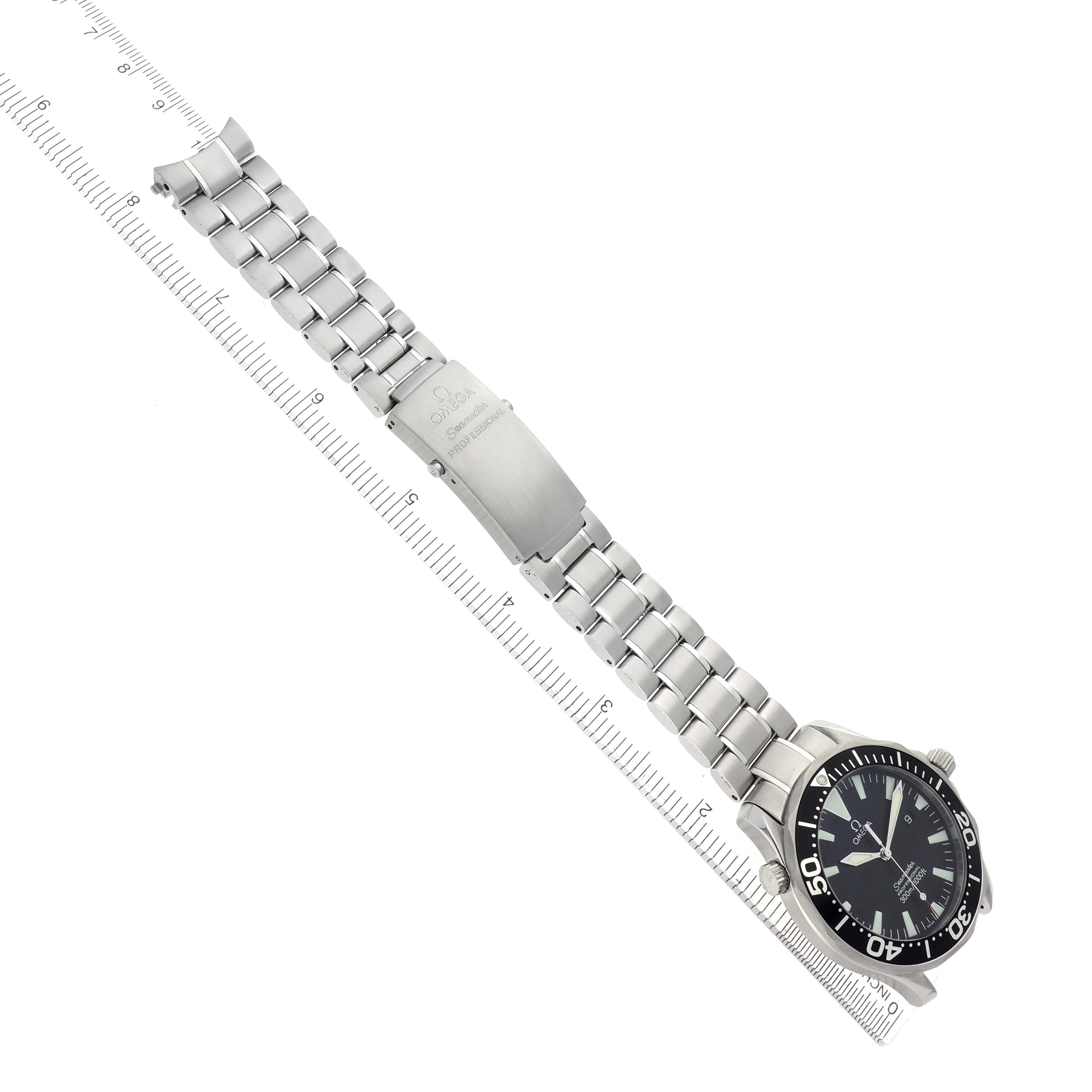 The image shows an Omega Seamaster 2264.50.00 Men
s Stainless Steel Black Dial 2264.50.00 Men
s Stainless Steel Black Dial watch at an angle, displaying its bracelet, clasp, and face alongside a ruler for scale.
