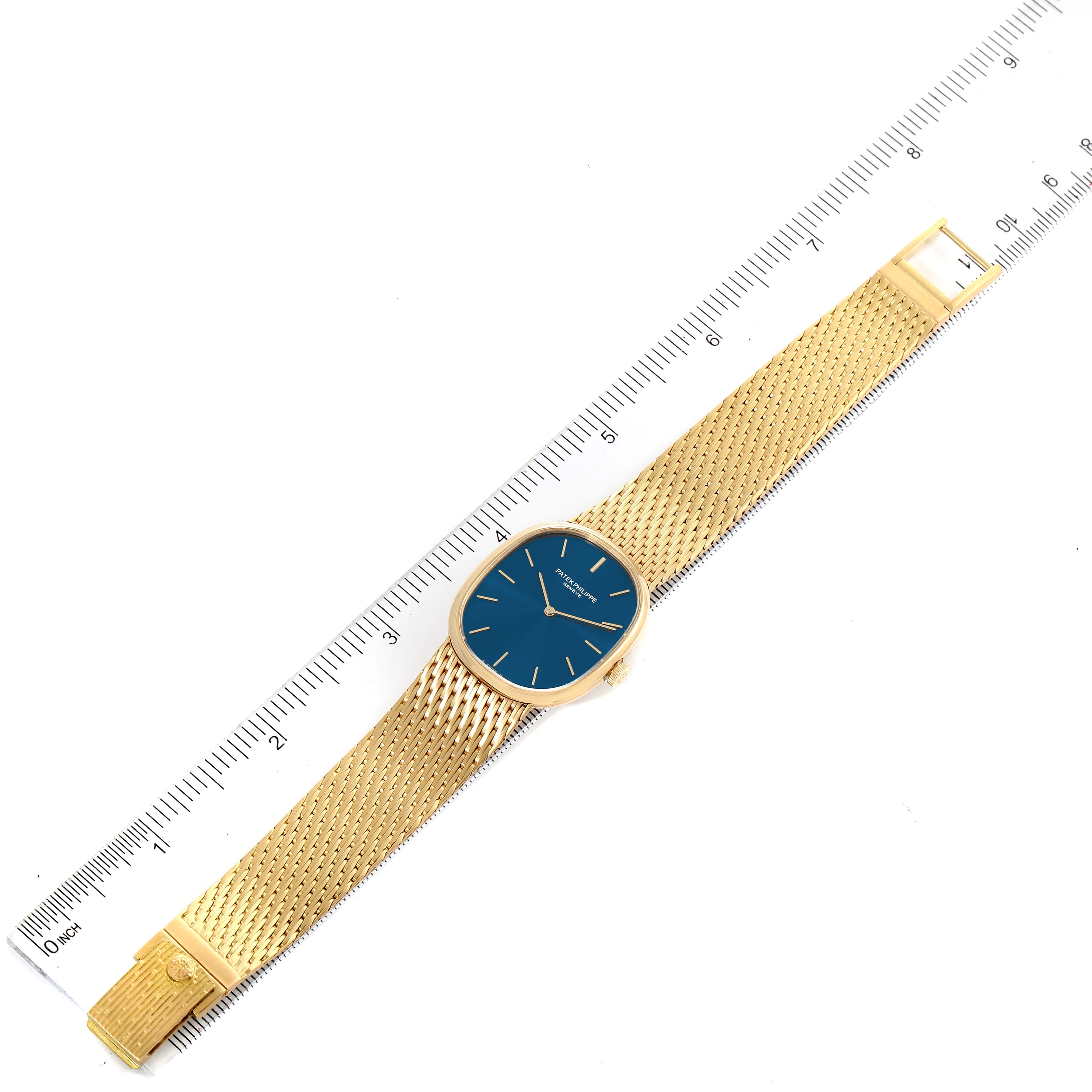 The Patek Philippe Golden Ellipse 3748/1 Men's Yellow Gold Blue Dial 3748/1 Men's Yellow Gold Blue Dial watch is shown from a top-down angle, with its entire watch face, strap, and a side ruler visible.