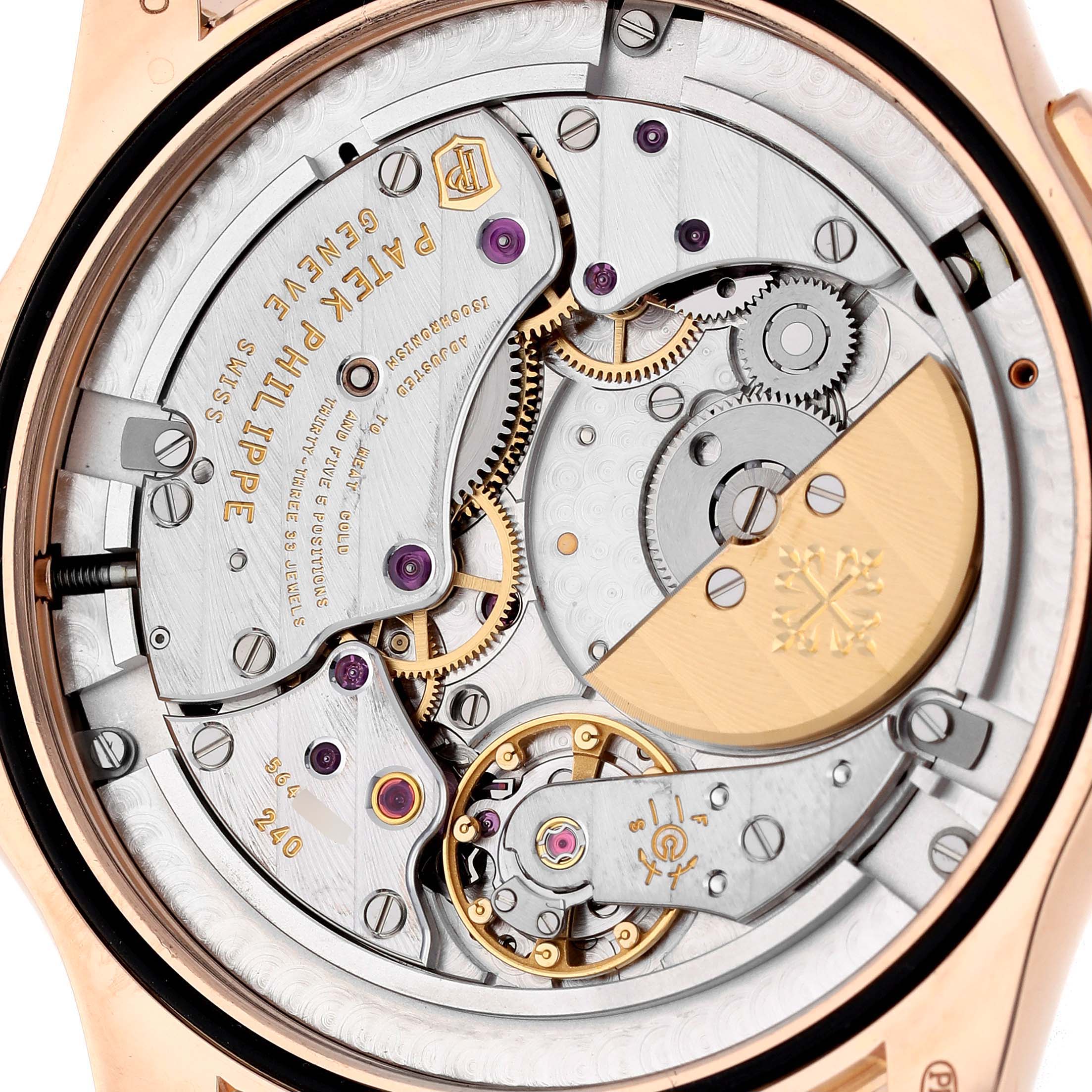 The image shows the intricate back view of a Patek Philippe Complications 5130/1R-011 Men's Rose Gold Brown Dial watch, highlighting its mechanical movement and gears.