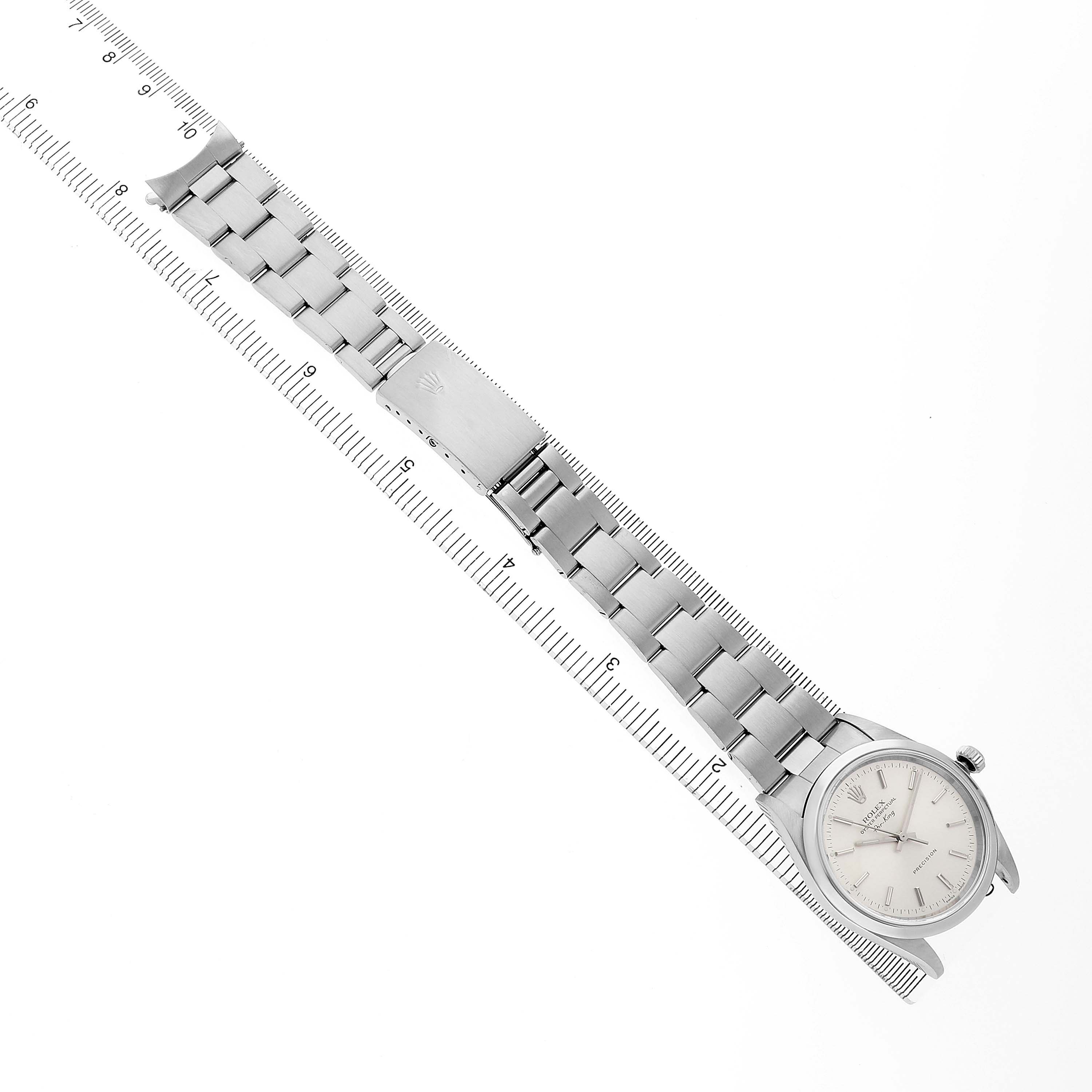 The image shows a top-down view of a Rolex Air-King 14000 Men's Stainless Steel Silver Dial watch, displaying the full bracelet and face beside a ruler.