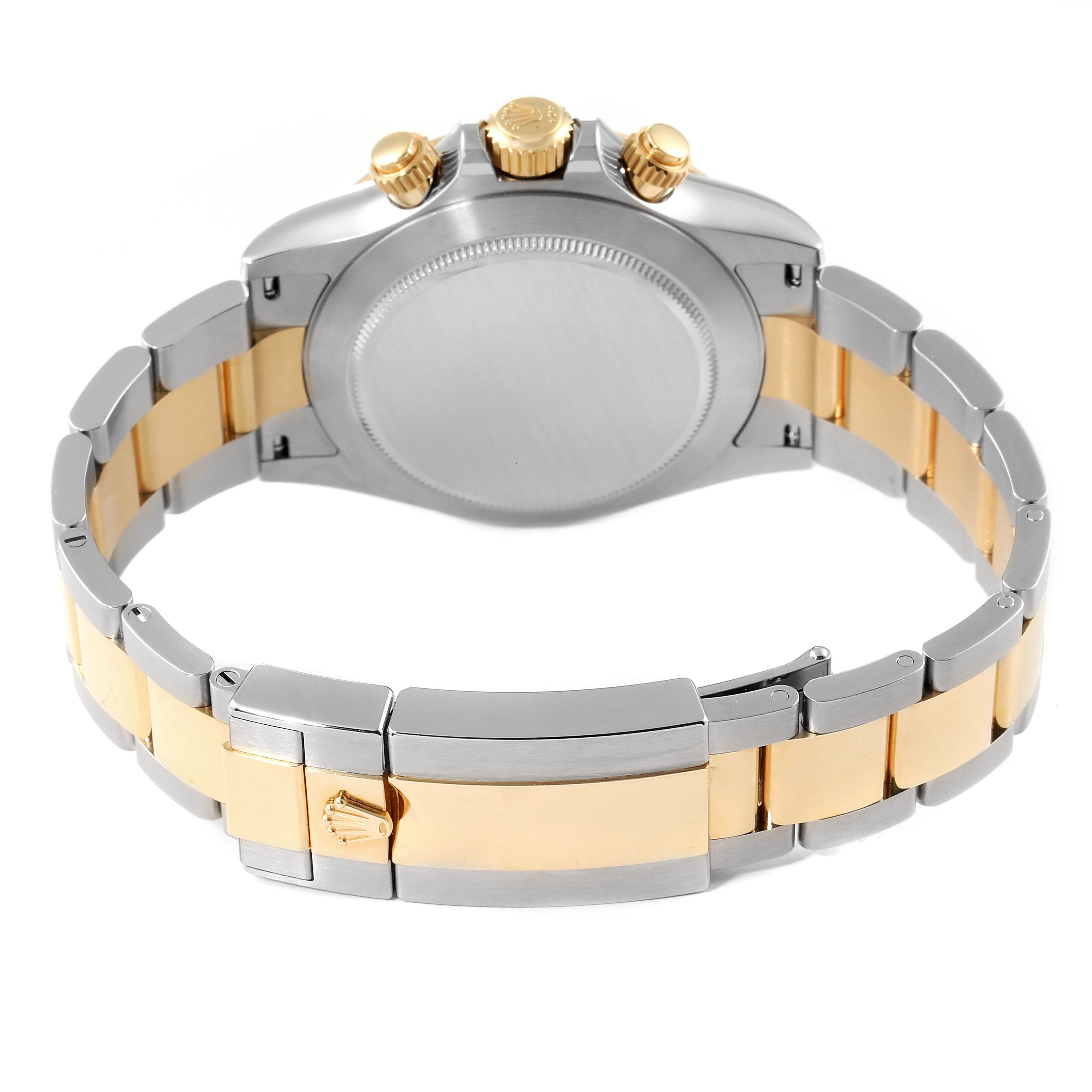 The image shows the back view of a Rolex Daytona 116503 Men
s Steel and Gold (two tone) Champagne Dial 116503 Men
s Steel and Gold (two tone) Champagne Dial watch, highlighting its clasp, bracelet, and three gold pushers/crown.