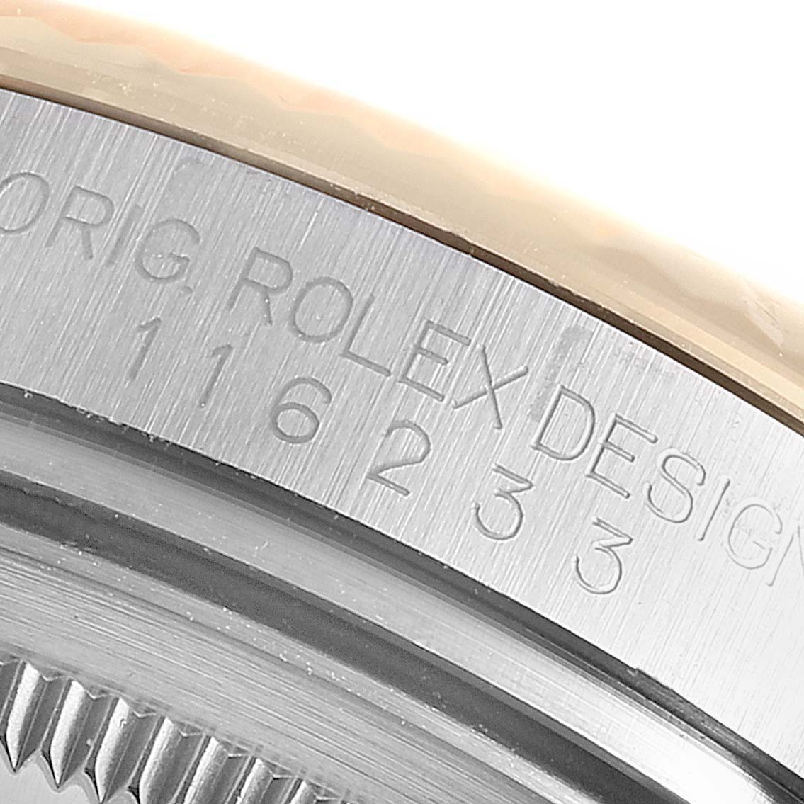 This image shows a close-up of the engraved side of a Rolex Datejust 116233 Men
s Steel and Gold (two tone) Black Dial 116233 Men
s Steel and Gold (two tone) Black Dial model watch, displaying "ROLEX DESIGN" and serial numbers.