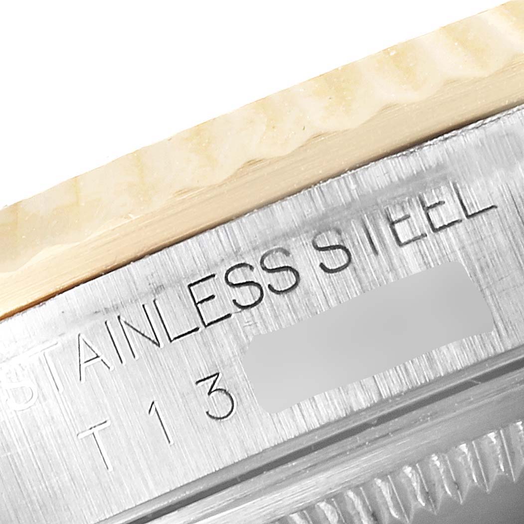 This close-up image of the Rolex Datejust 16233 Men
s Steel and Gold (two tone) Black Dial 16233 Men
s Steel and Gold (two tone) Black Dial model showcases the stainless steel casing with part of the engraved text visible.