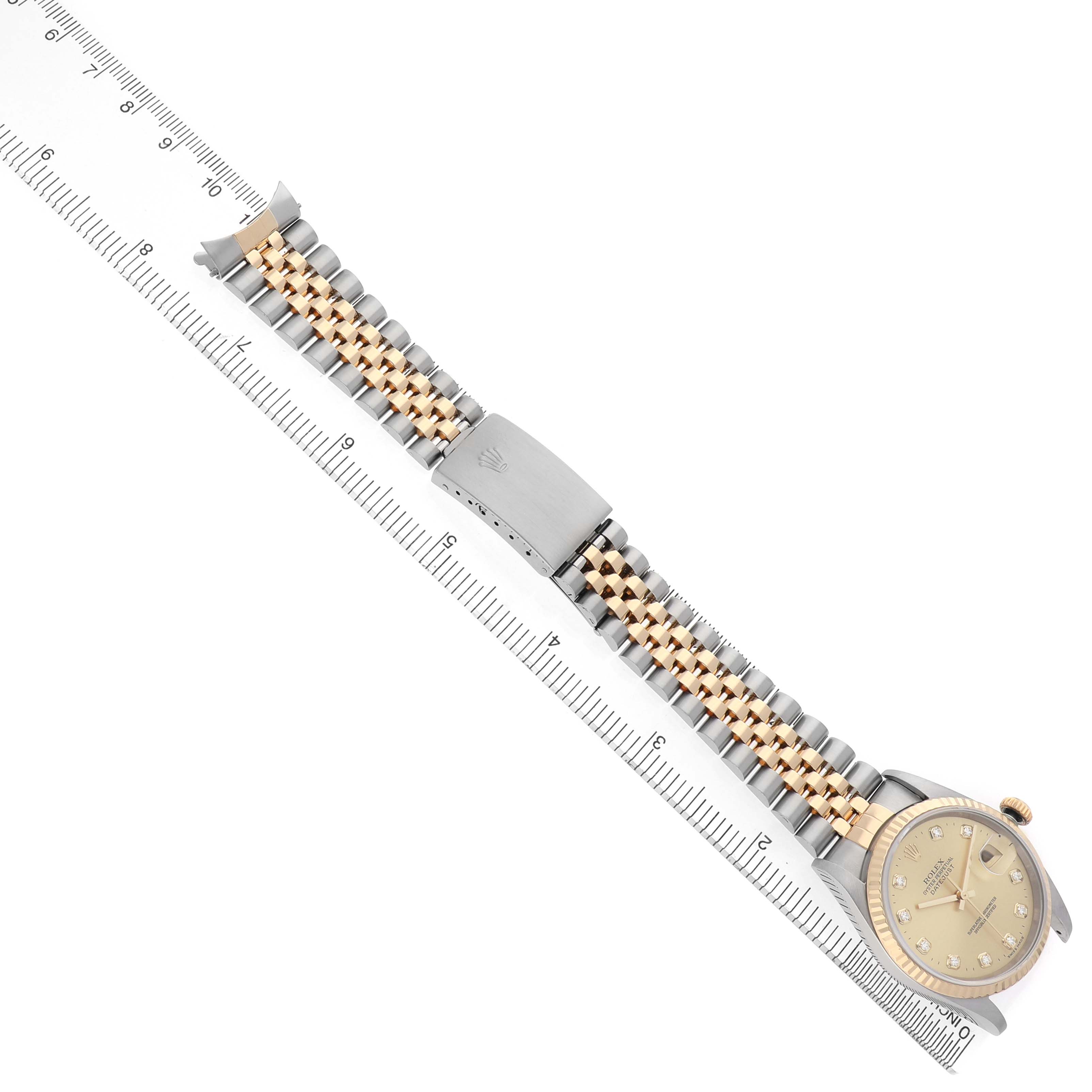 The image shows the Rolex Datejust 16233 Men's Stainless Steel Champagne Dial watch from a top-down angle, highlighting the full bracelet and clasp alongside a ruler for scale.