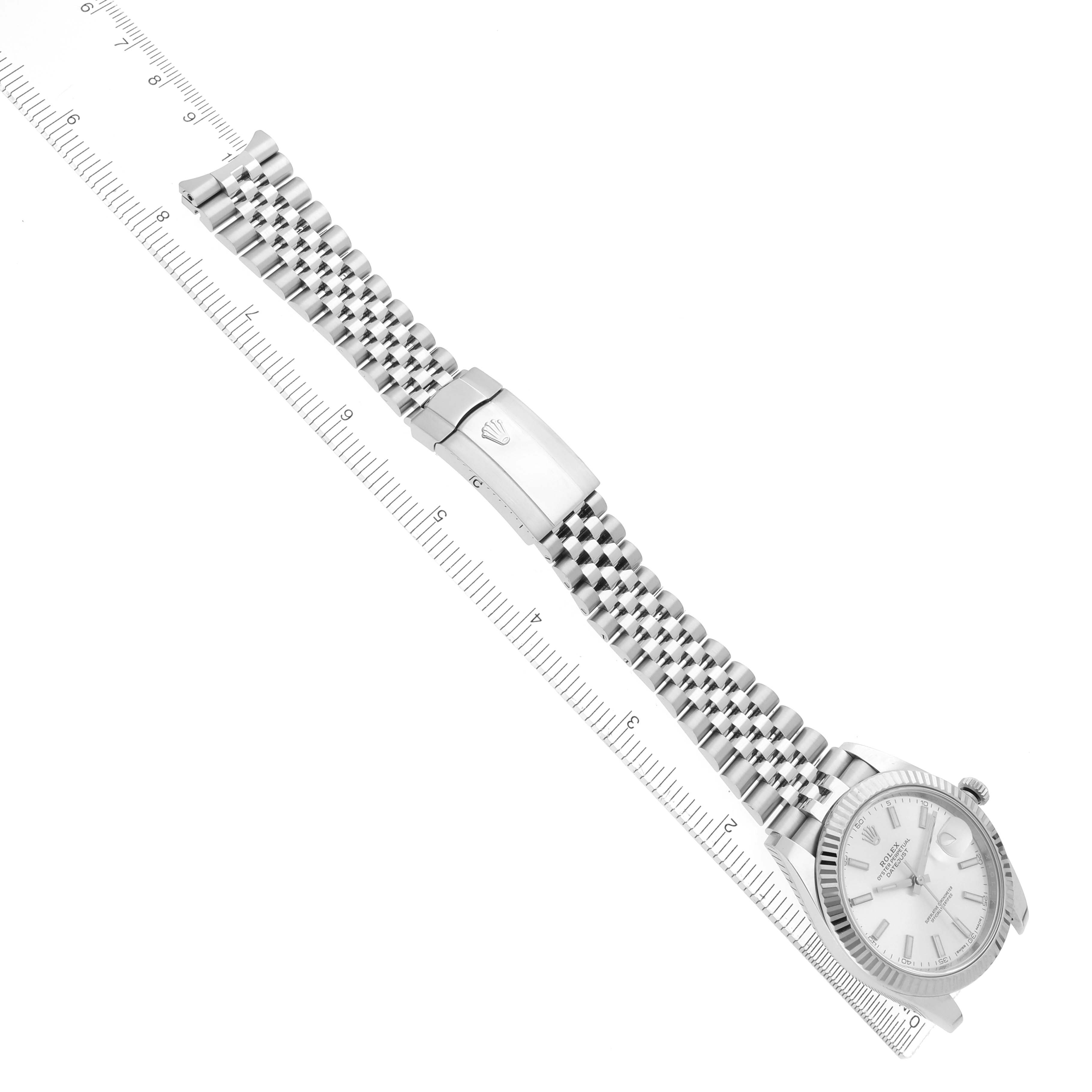The Rolex Datejust 41 126334 Men
s Stainless Steel Silver Dial 126334 Men
s Stainless Steel Silver Dial watch is shown flat with its face, bracelet, and clasp visible alongside a ruler for scale.