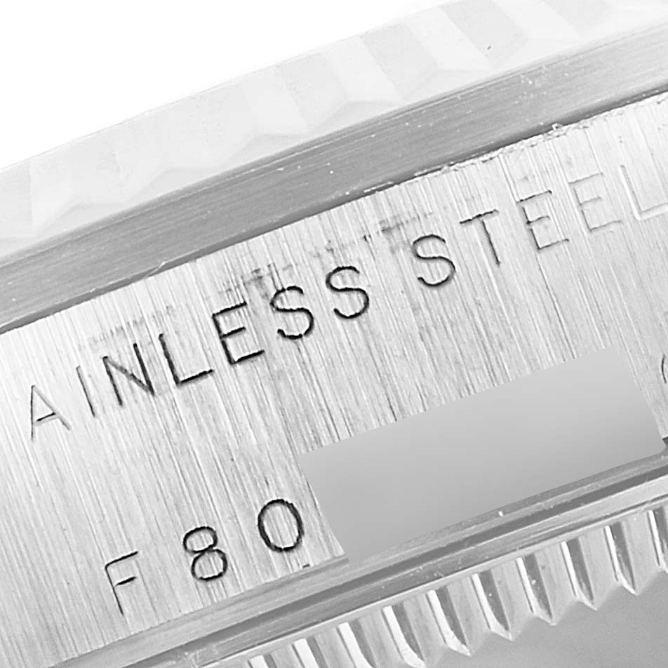 The image shows a close-up angled view of the side of a Mid-Size Rolex watch, highlighting the "STAINLESS STEEL" engraving.