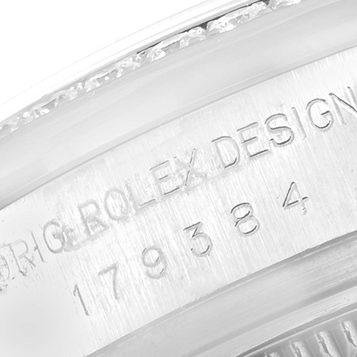 The image shows a close-up of the side engraving on a Rolex Datejust 179384 Women
s Stainless Steel Pink Dial 179384 Women
s Stainless Steel Pink Dial watch, displaying its design and serial numbers.