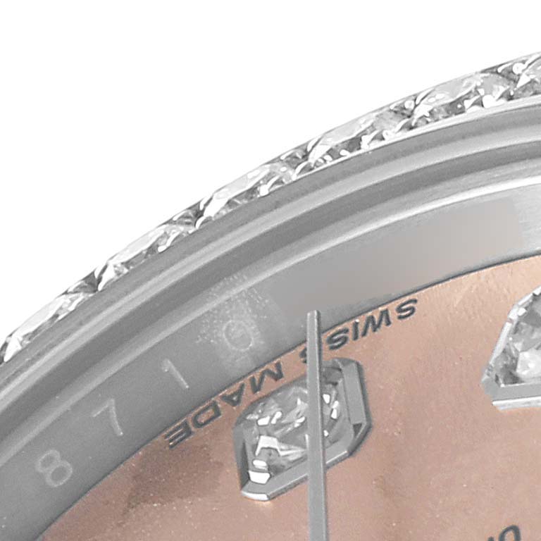 This close-up of the Rolex Datejust 179384 Women
s Stainless Steel Pink Dial 179384 Women
s Stainless Steel Pink Dial watch shows part of the bezel, dial, hour markers, and minute hand.