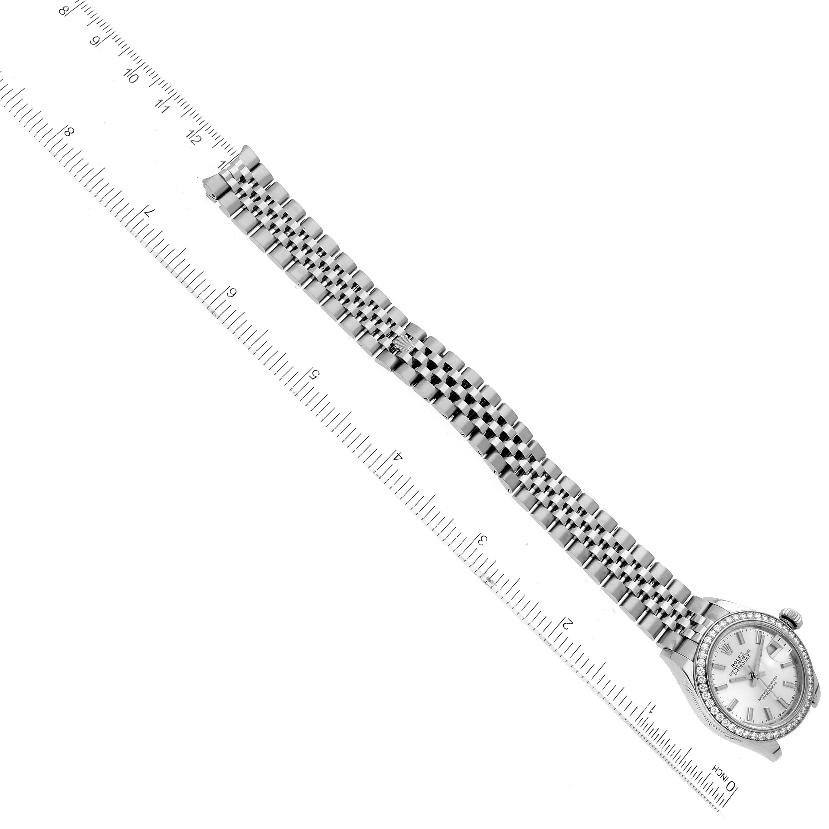 The image shows a Rolex Datejust 279384RBR Women's Stainless Steel Silver Dial 279384RBR Women's Stainless Steel Silver Dial watch shot from a top-down view, highlighting the watch face, bezel, and metal bracelet aligned parallel to a ruler.