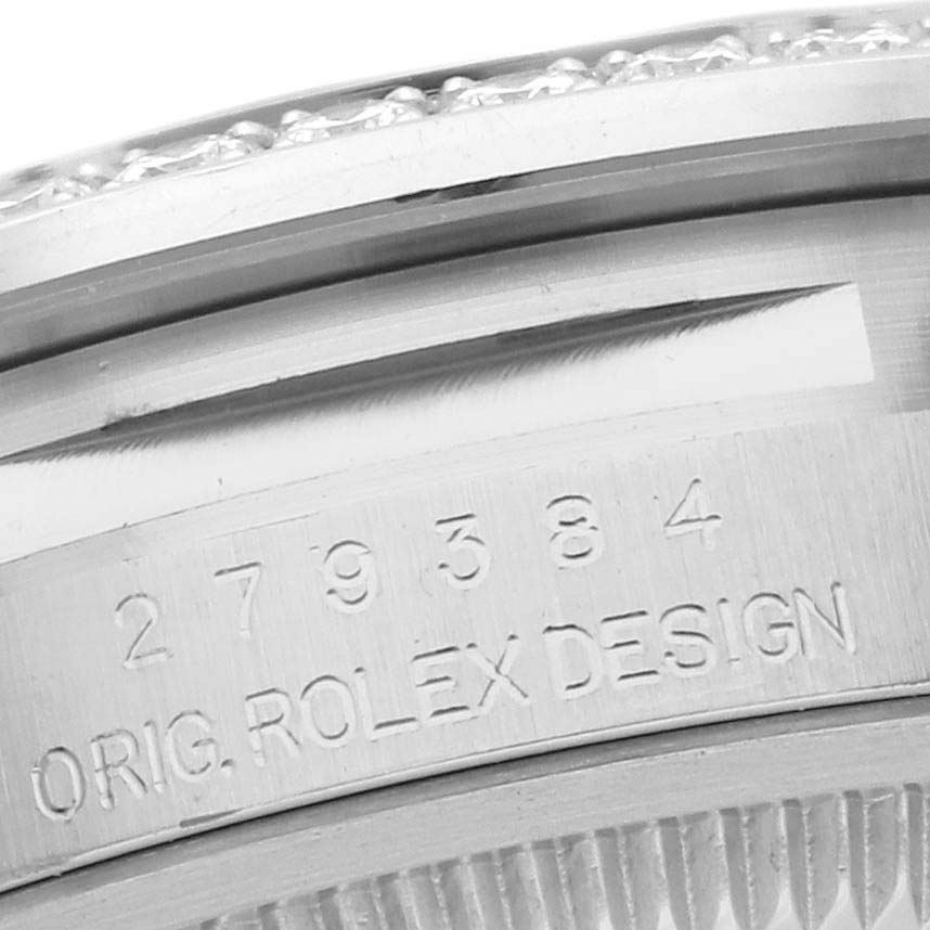 The image shows a close-up of the engraved case side of the Rolex Datejust 279384RBR Women's Stainless Steel Silver Dial 279384RBR Women's Stainless Steel Silver Dial watch with some serial numbers and "ORIG. ROLEX DESIGN" visible.