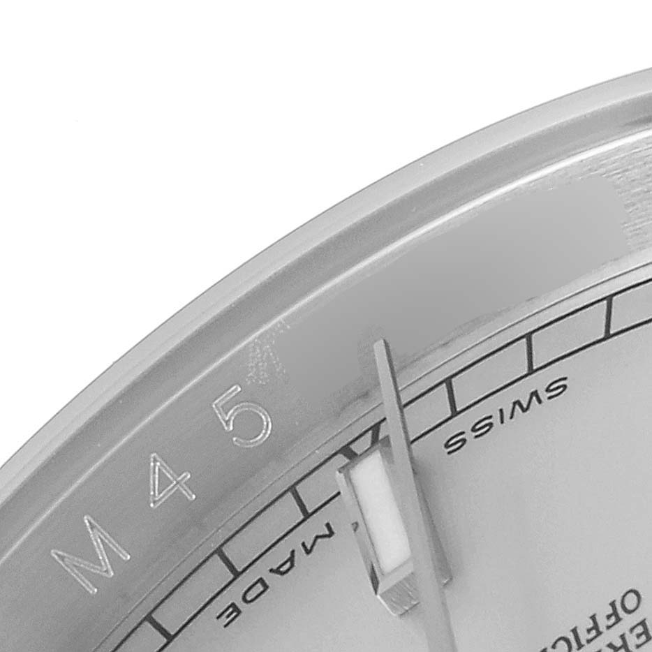 This close-up of a Rolex Datejust 116234 Men's Stainless Steel Silver Dial 116234 Men's Stainless Steel Silver Dial watch shows a segment of the dial near the 4 and 5 markers with part of the minute hand visible.